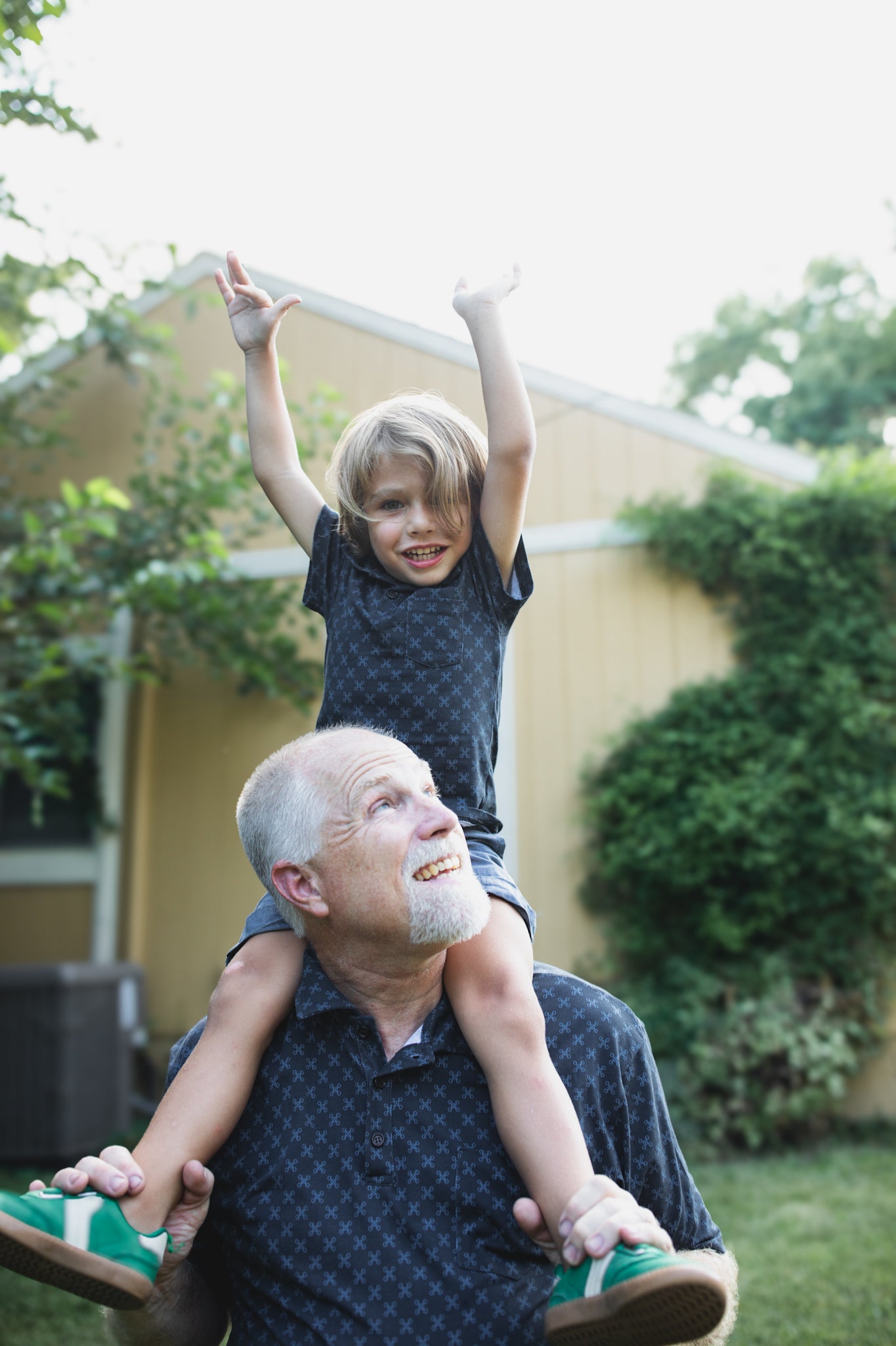 Young boy wearing a dark blue polo shirt with his father in a matching shirt