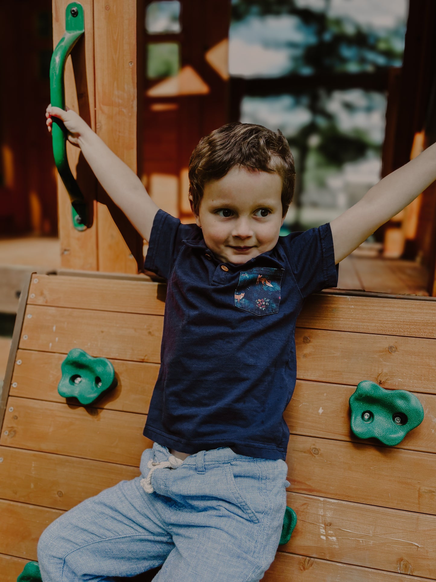 Child playing on playground with climbing grips.