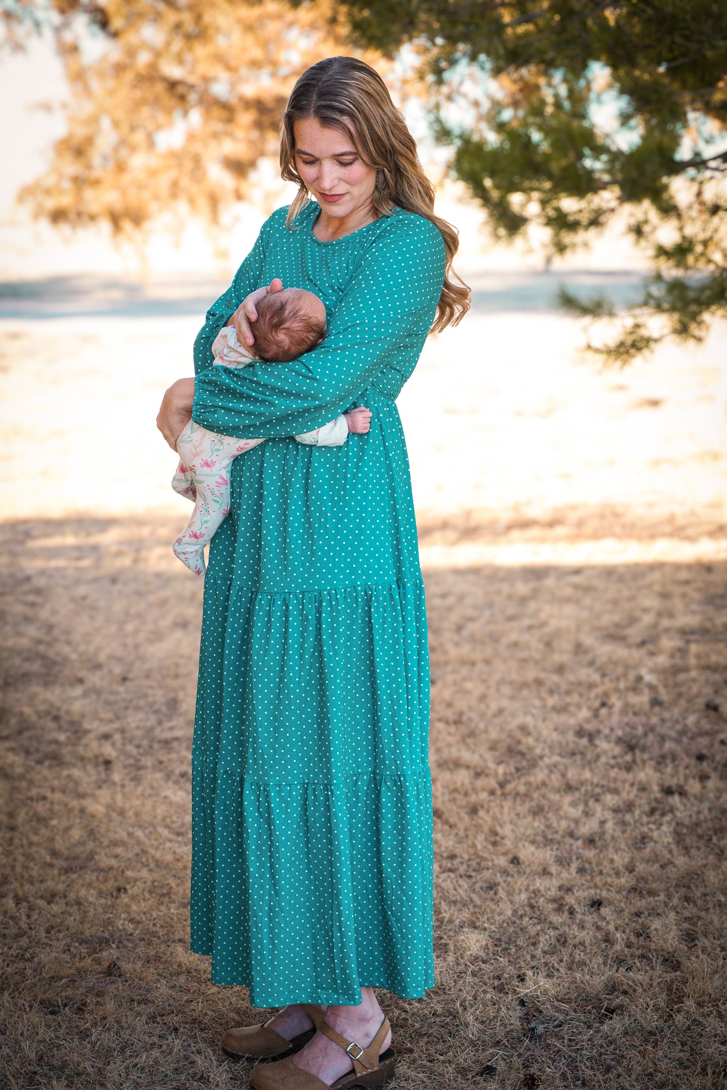 woman wearing modest nursing dress with her baby in hand