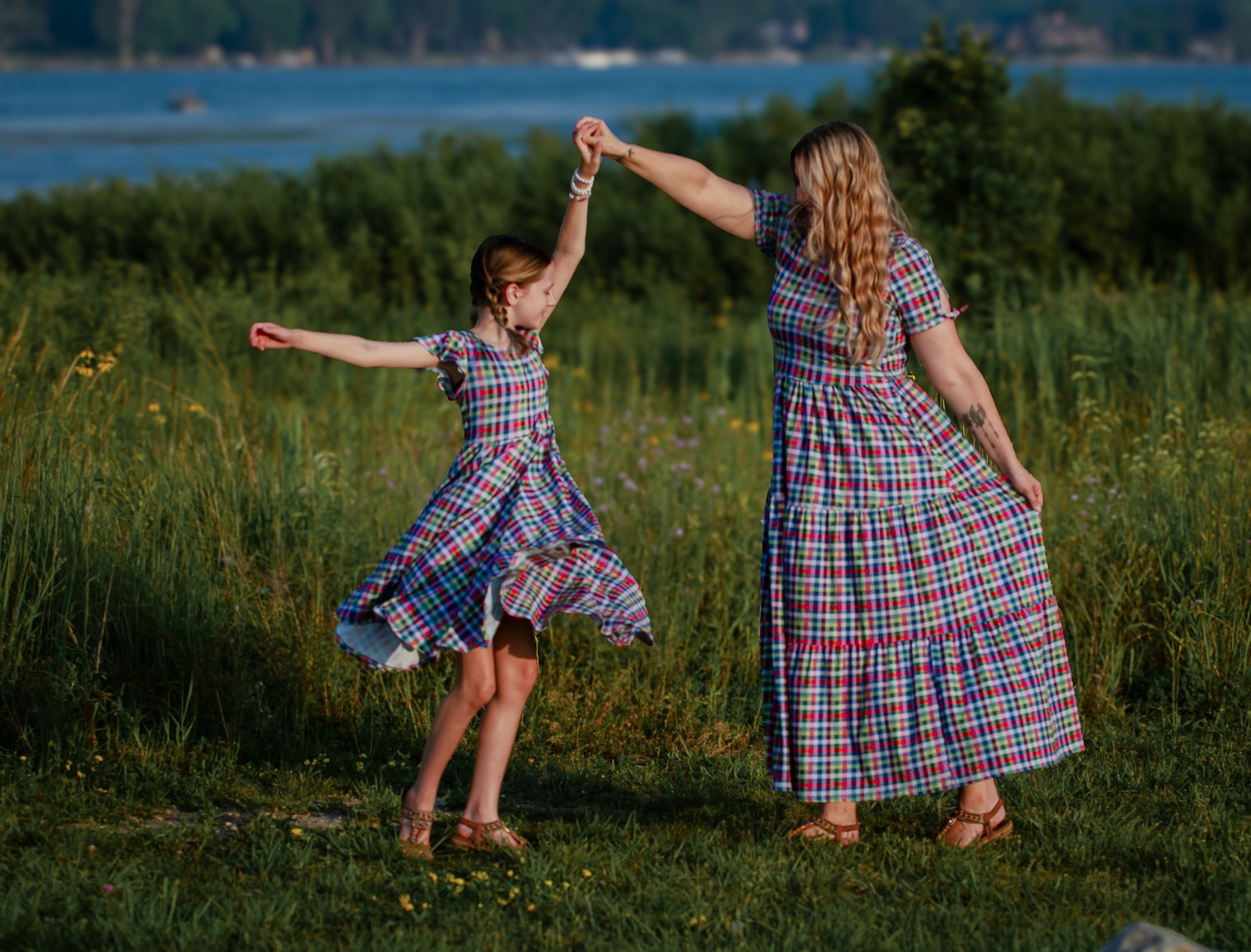 Young girl in a colorful checkered modest dress with her mother in a colorful modest nursing dress