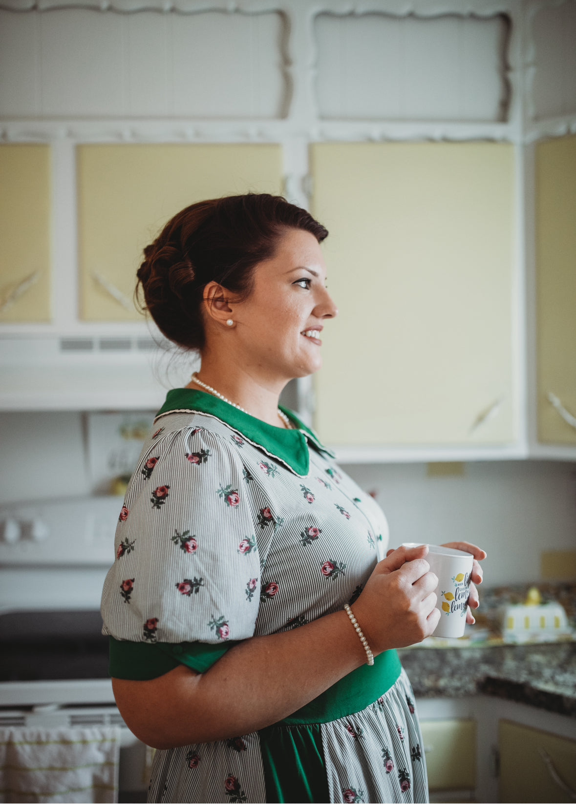 woman wearing a green and white striped modest nursing dress