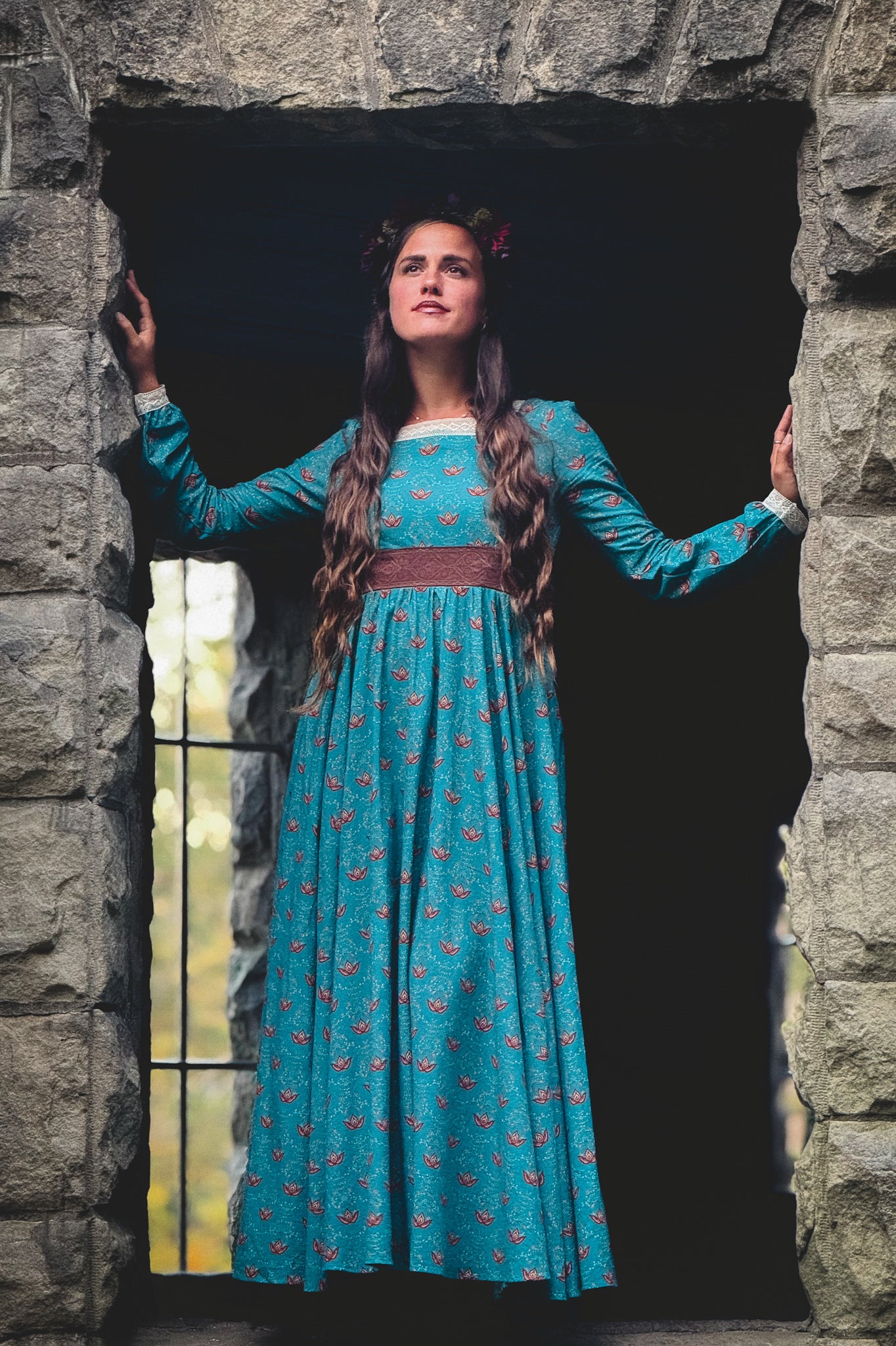 Woman in modest nursing blue dress in archway