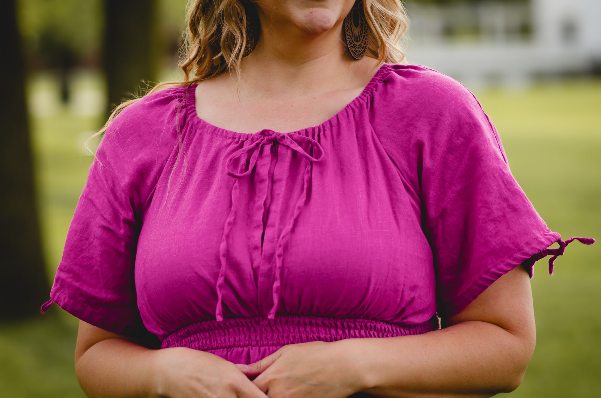 Woman wearing a pink modest nursing dress standing outdoors with a blurred background
