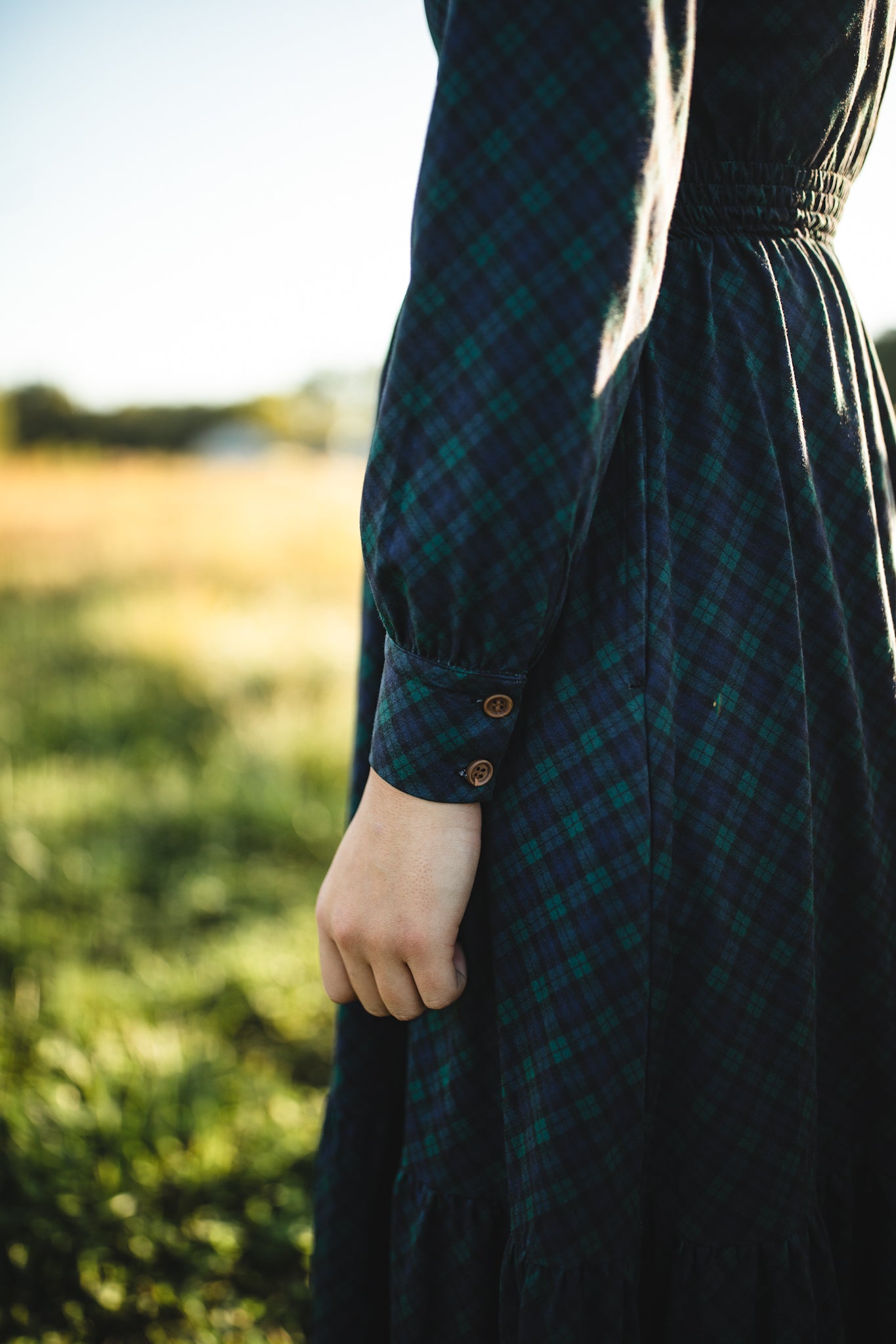 Woman in modest nursing green plaid dress outdoors