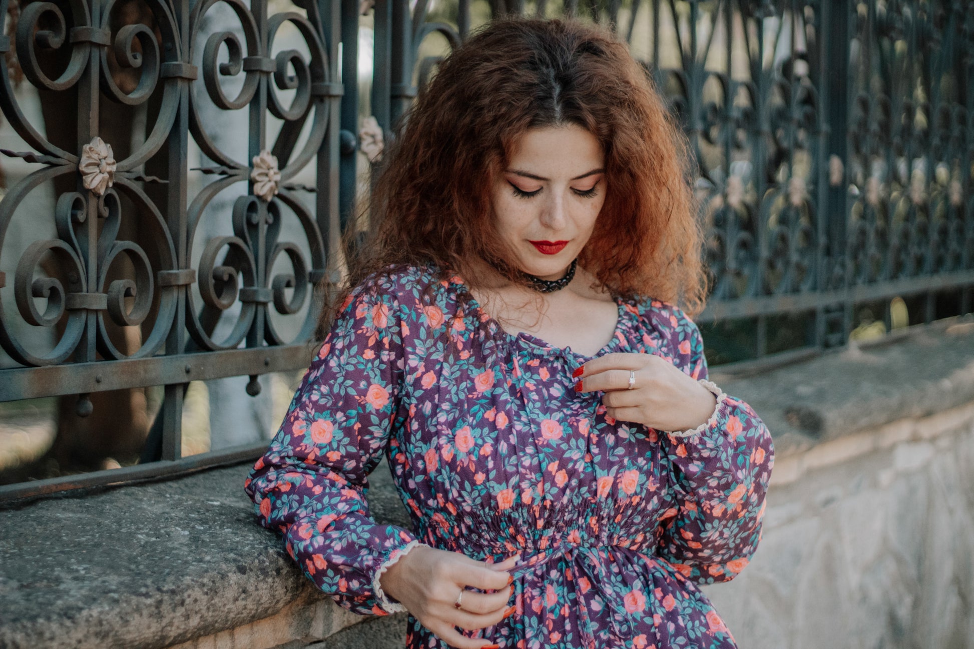 Woman in modest nursing floral dress by gate