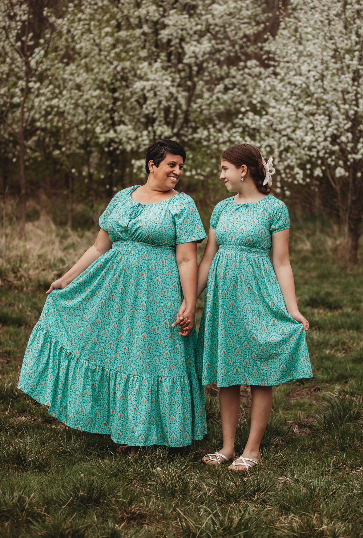 Young girl wearing a modest green dress with her mother in a modest green nursing dress