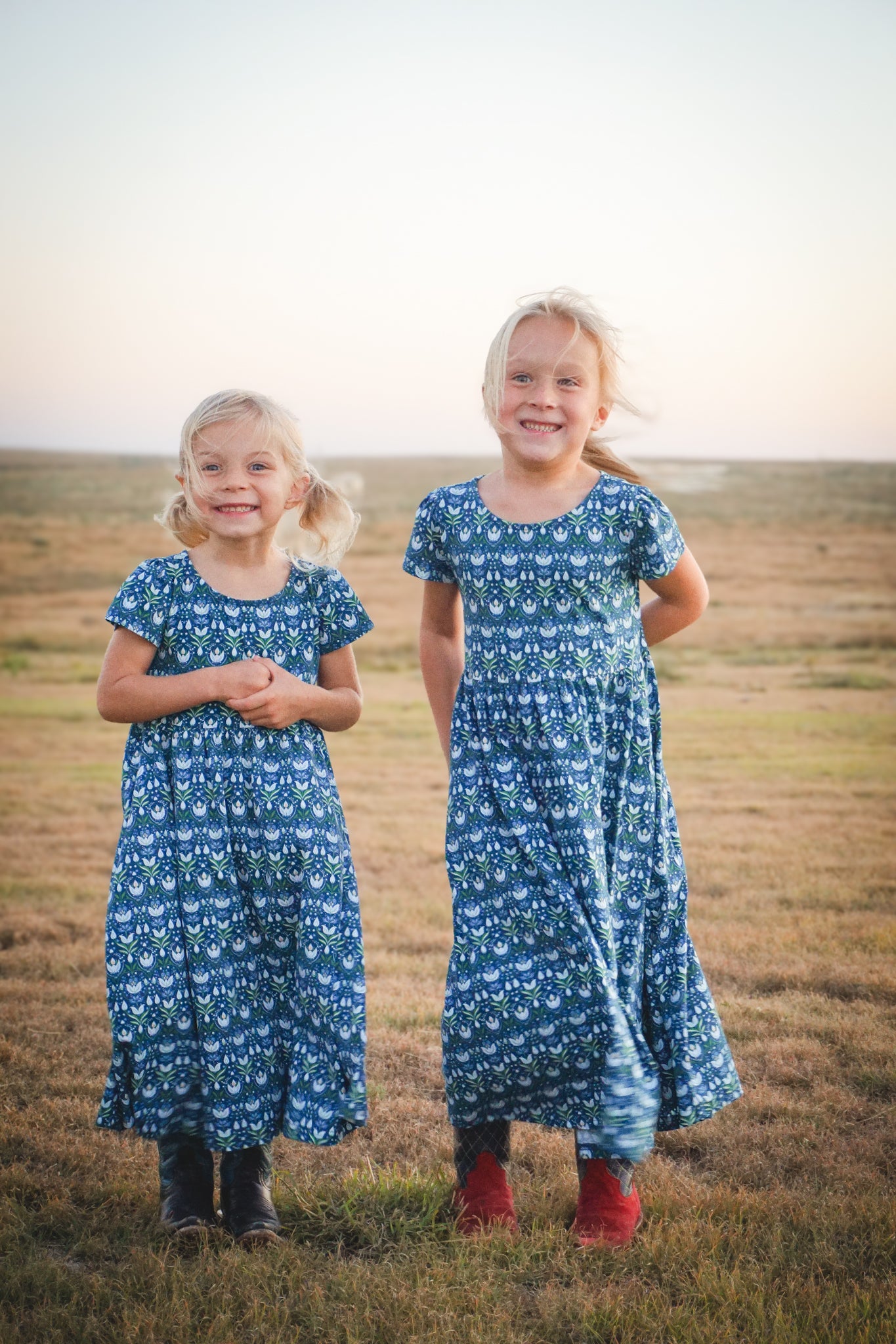 Two girls in modest nursing dresses outdoors at sunset