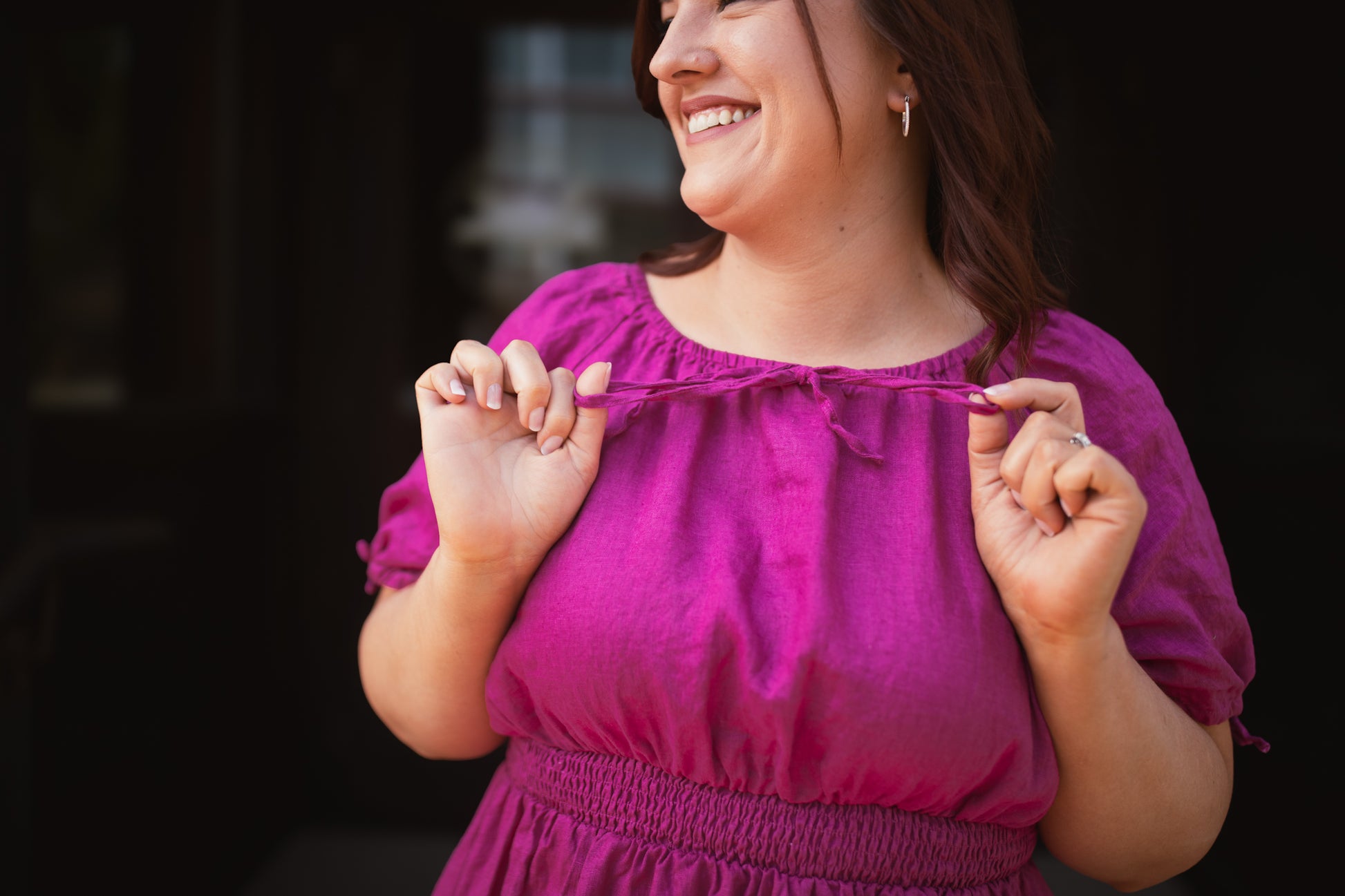 Woman wearing a pink modest nursing dress with a blurred background