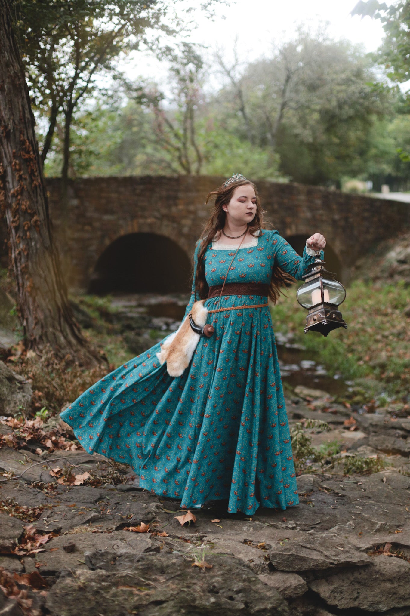 Woman in modest nursing blue dress holding lantern