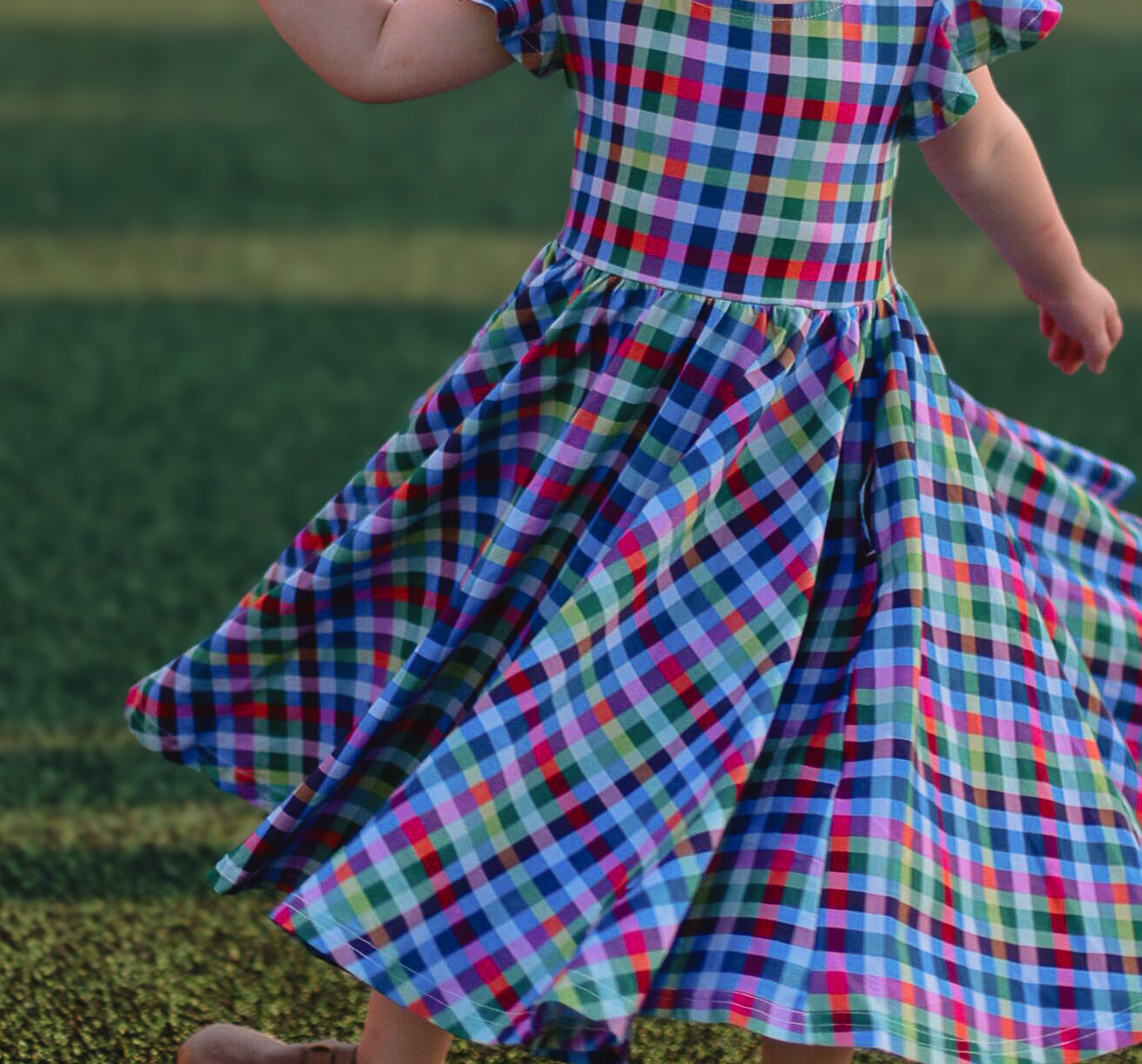 Young girl in a colorful checkered modest dress