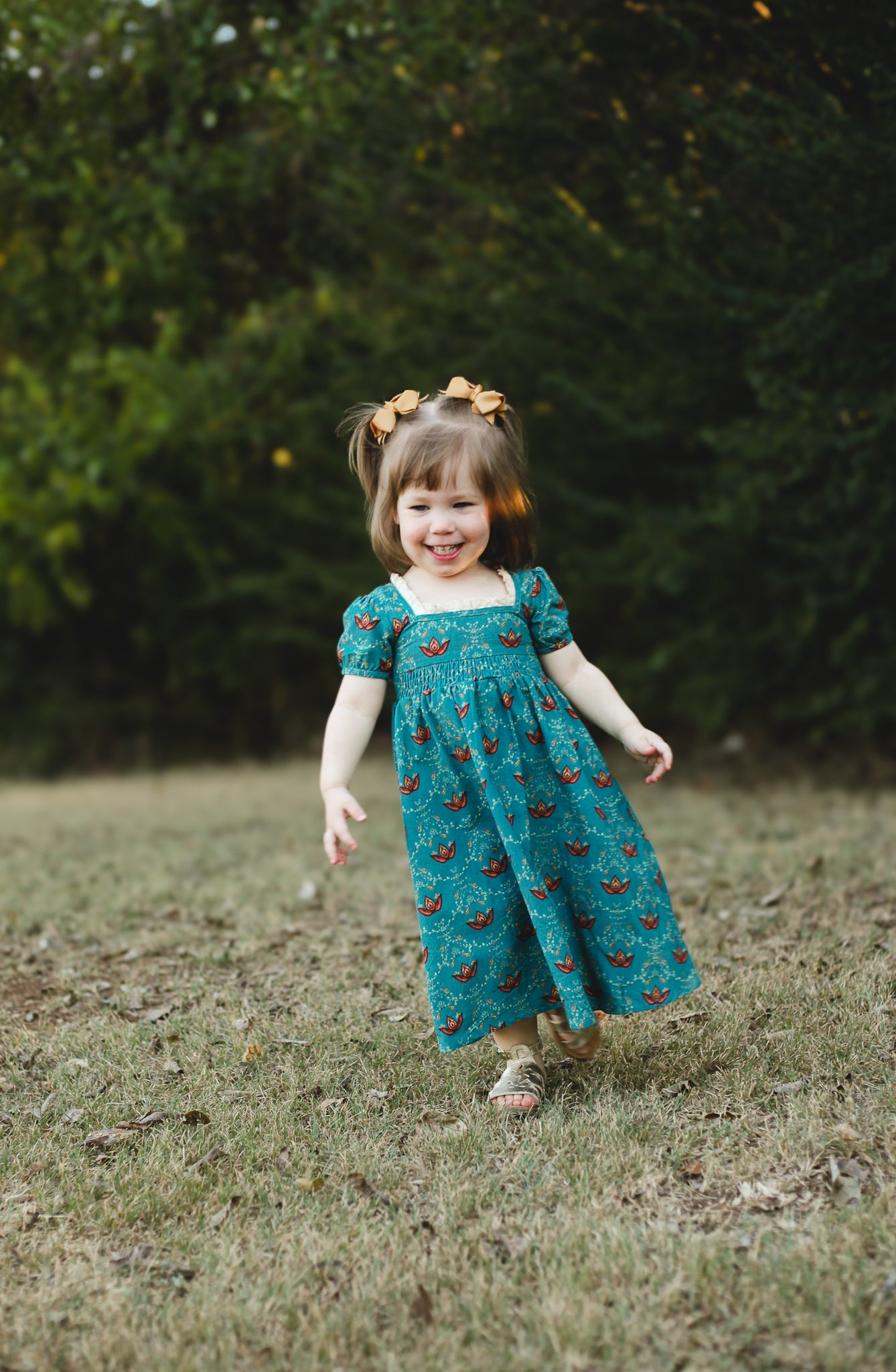 Young girl in modest dress with patterns outdoors.