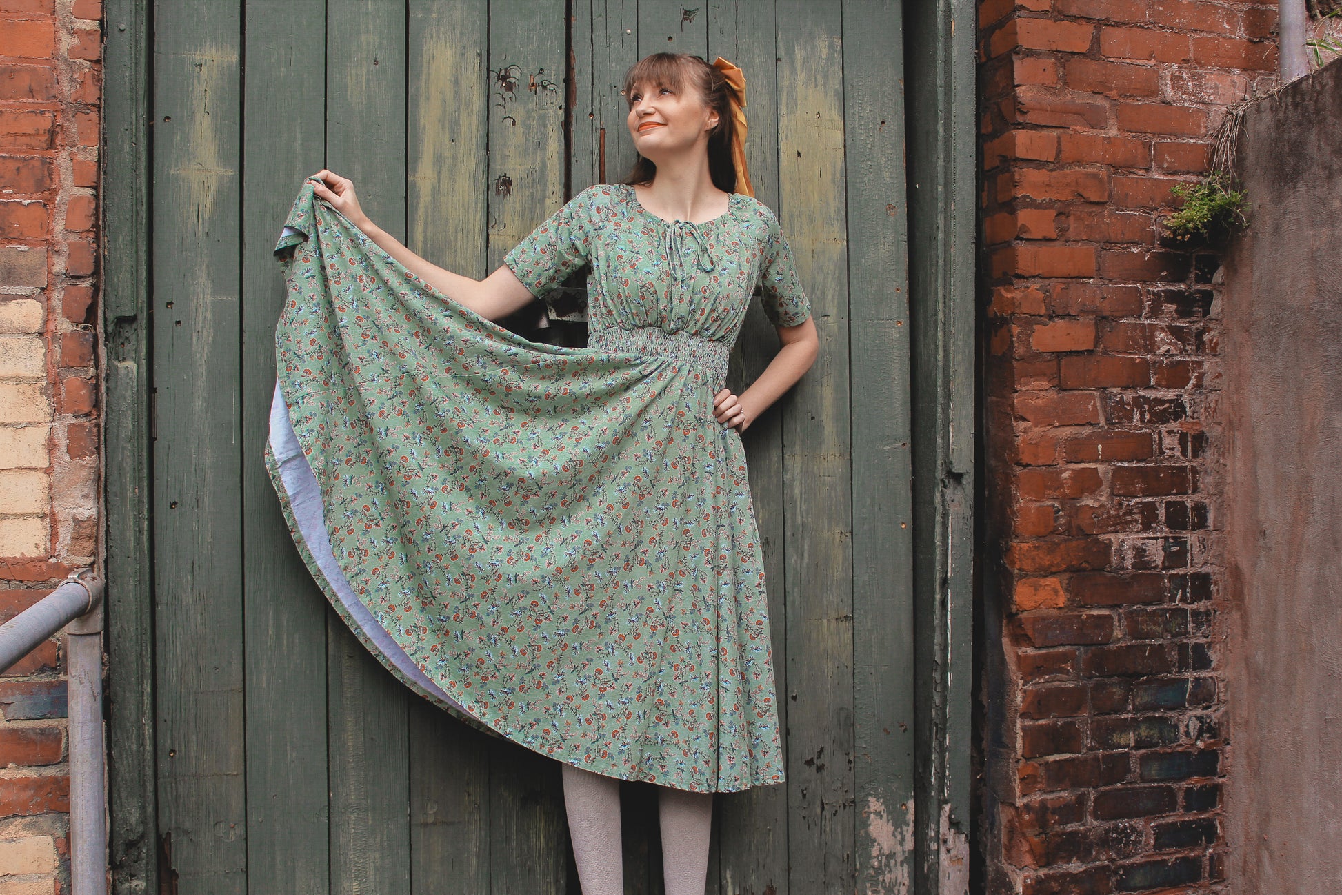 Woman in modest nursing floral dress by door