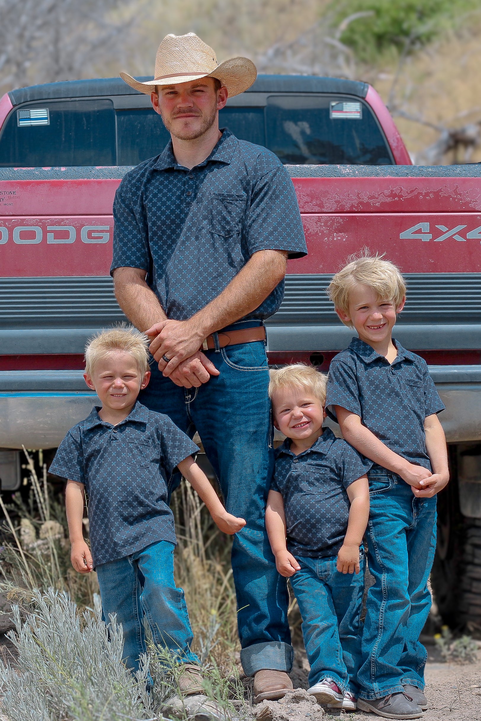 Young boys wearing dark blue polo shirts with their father in a matching shirt