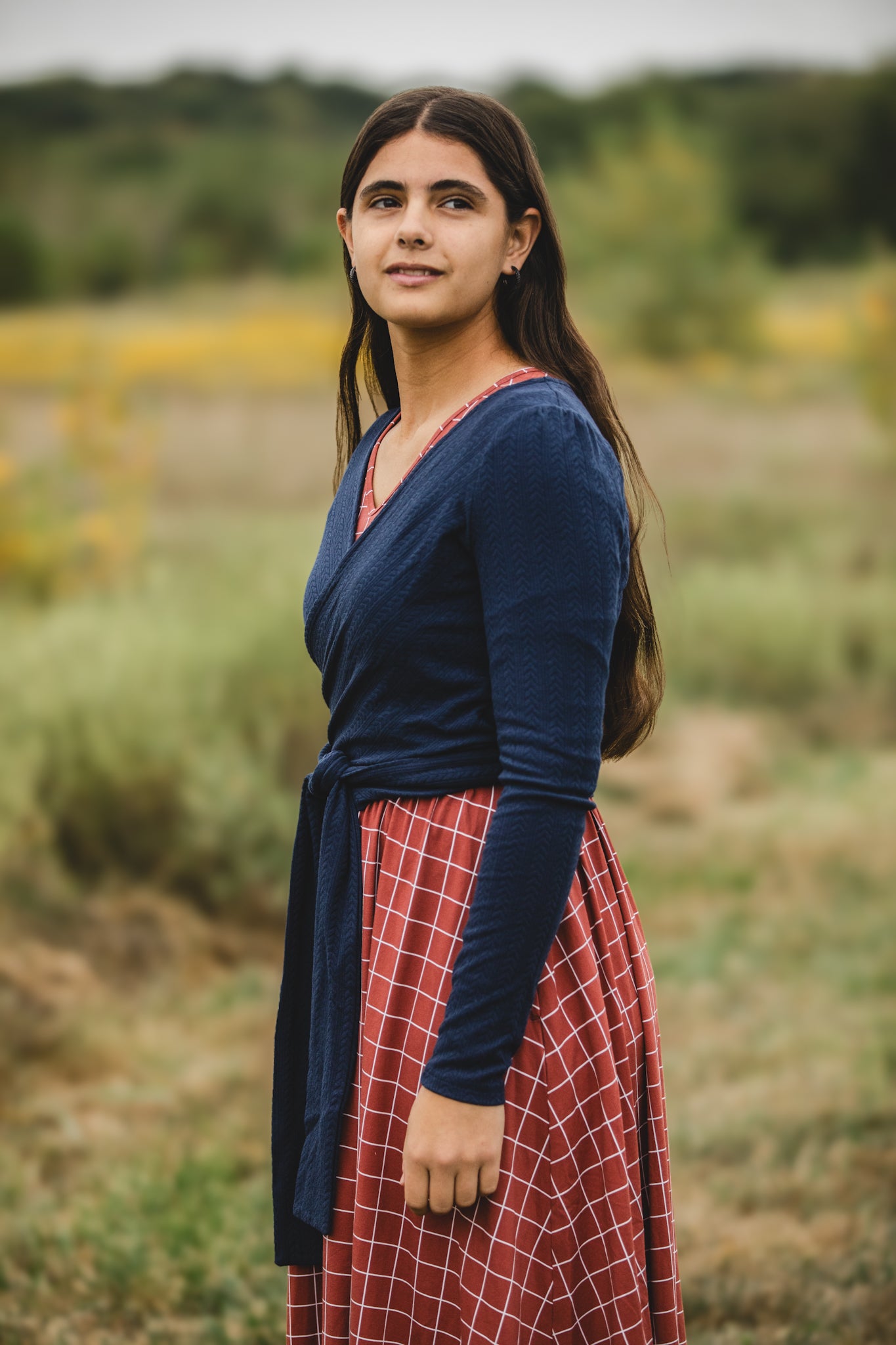 Woman in modest nursing copper windowpane maxi dress