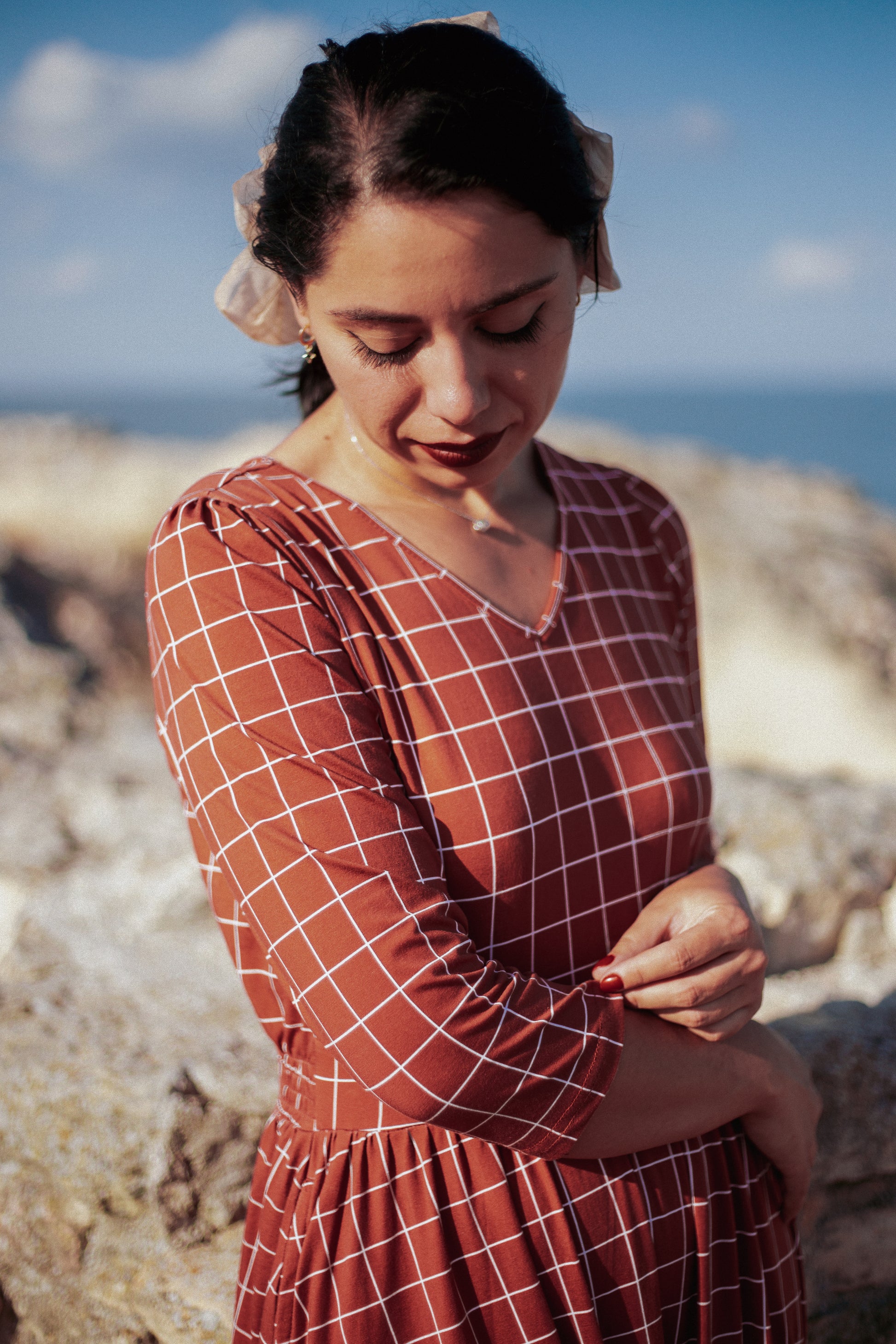 Woman wearing modest nursing copper dress sitting outdoors