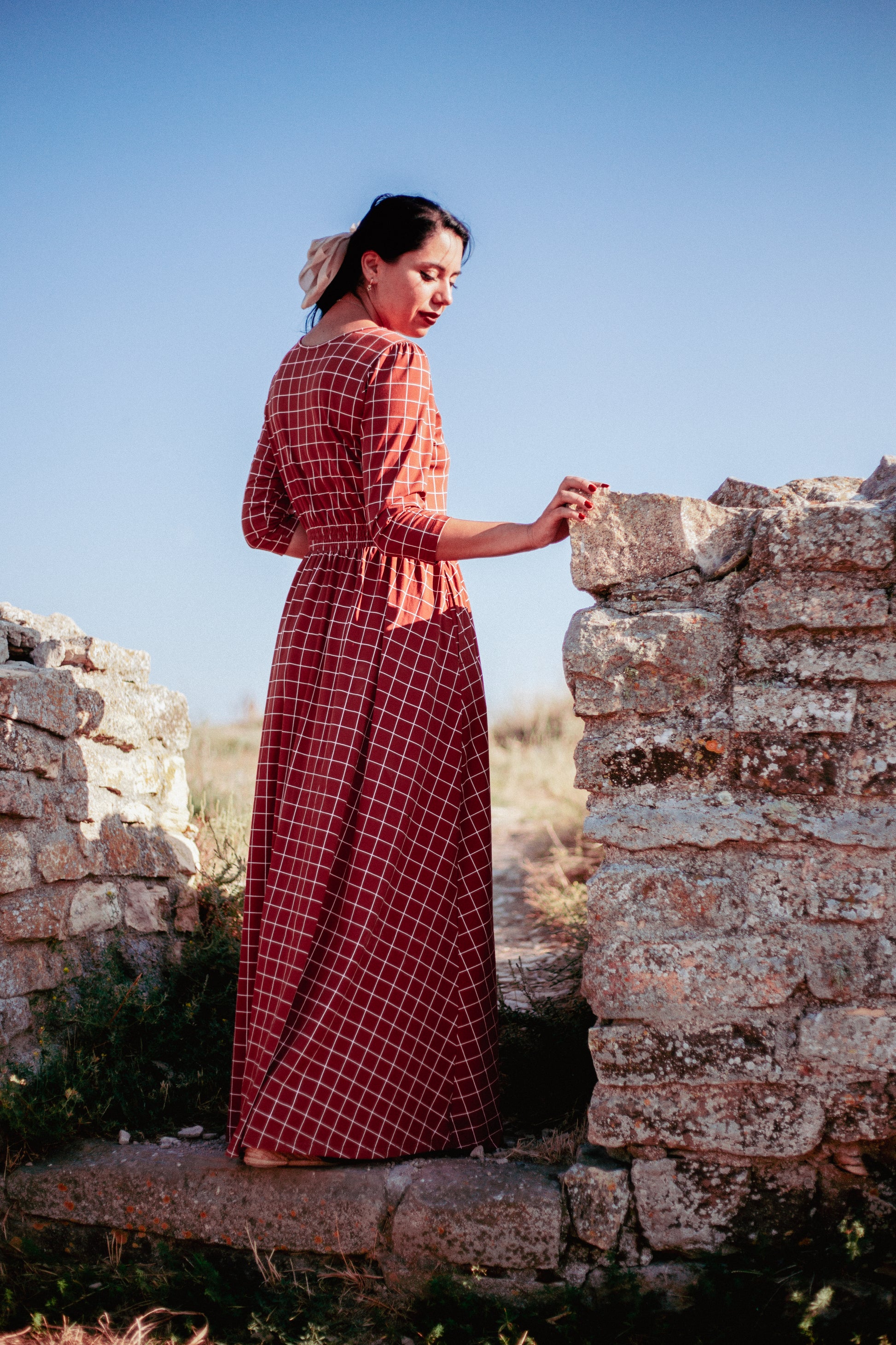 Woman in modest nursing copper windowpane maxi dress