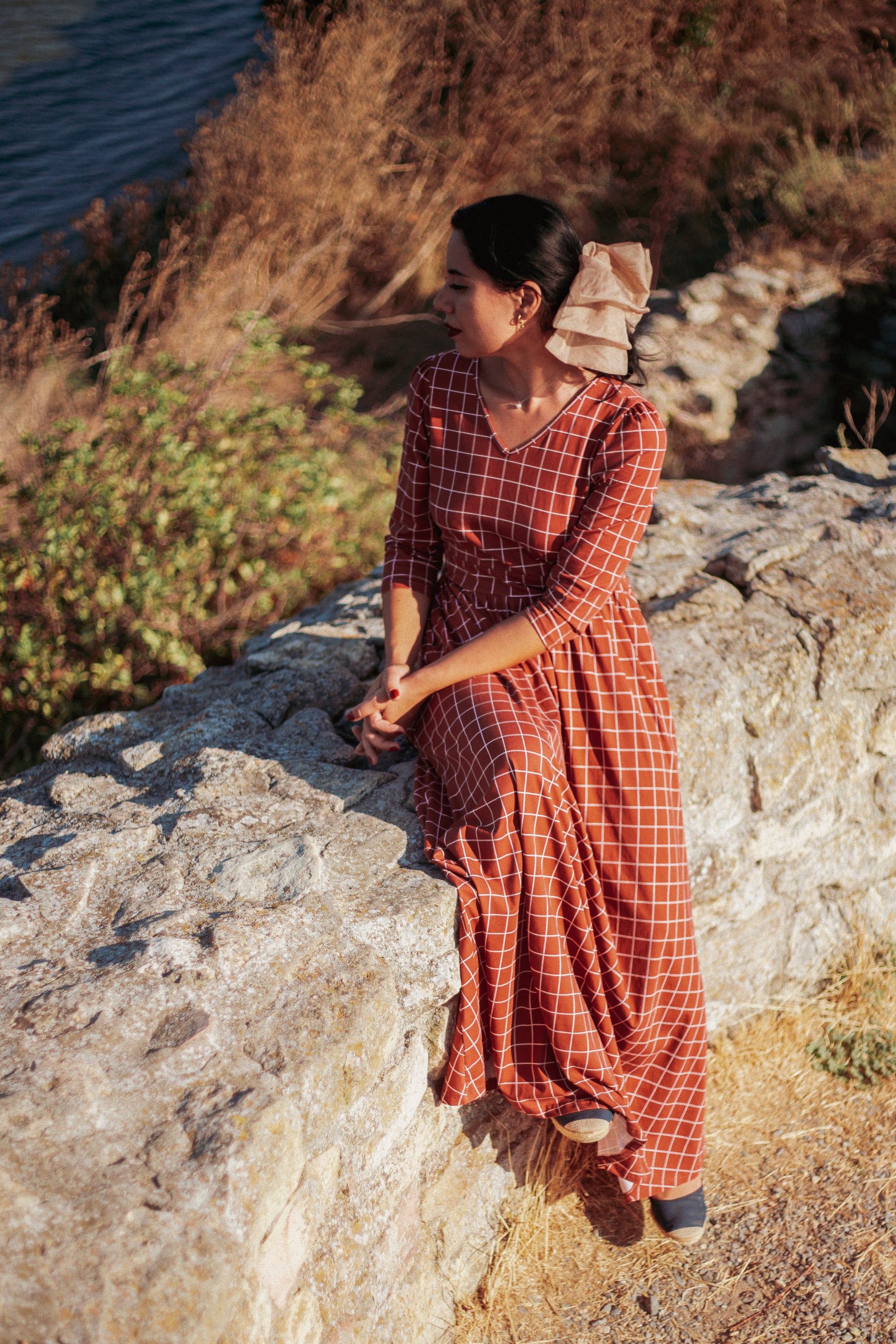 Woman in modest nursing copper windowpane maxi dress