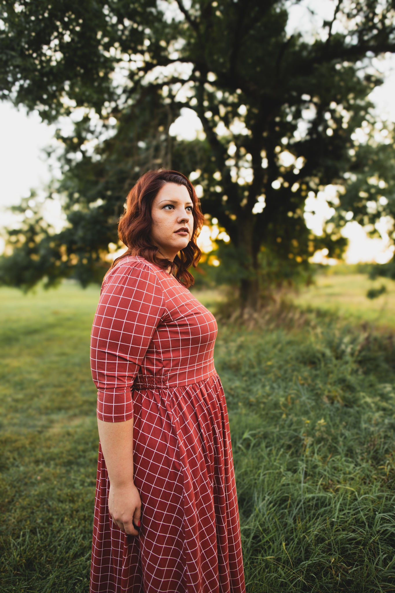 Woman in modest nursing copper windowpane maxi dress