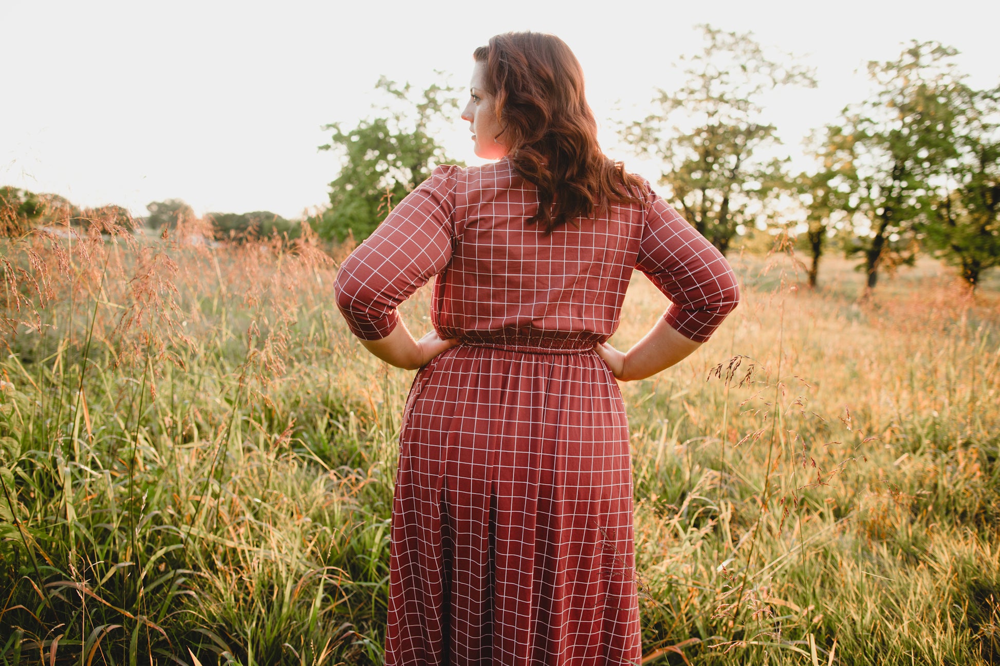 Woman in modest nursing copper windowpane maxi dress