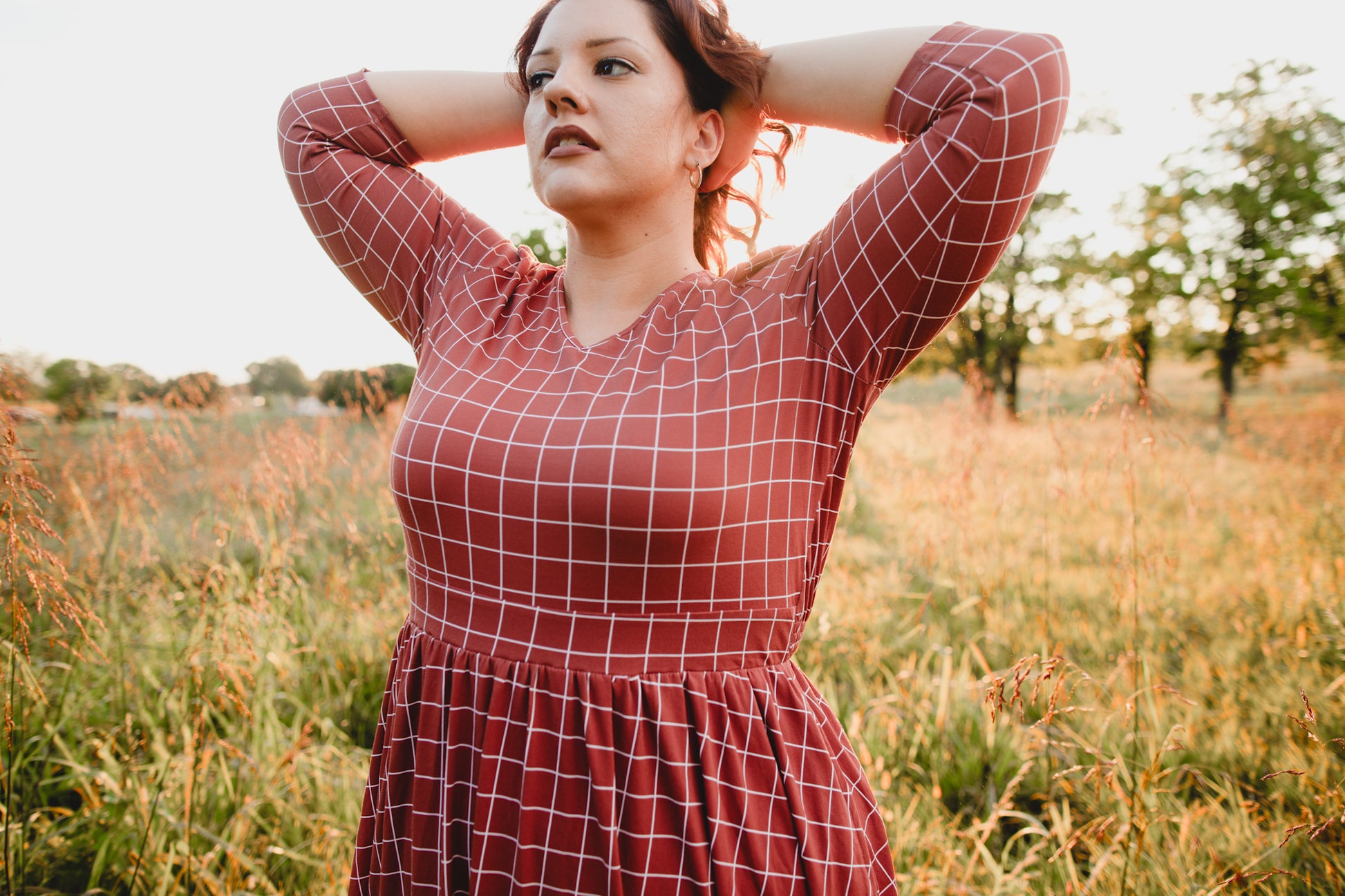 Woman in modest nursing copper windowpane maxi dress