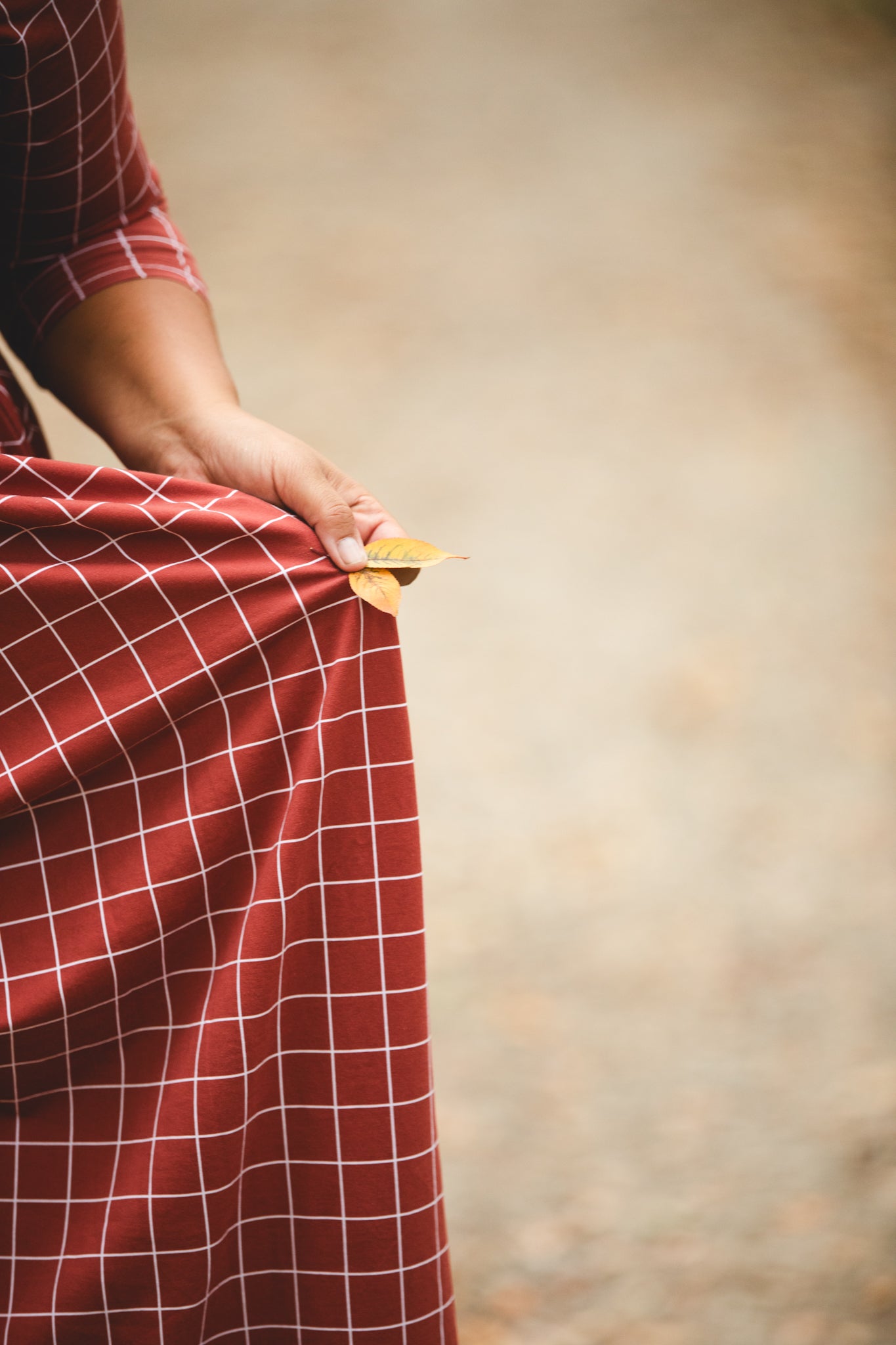 Woman in modest nursing copper windowpane maxi dress