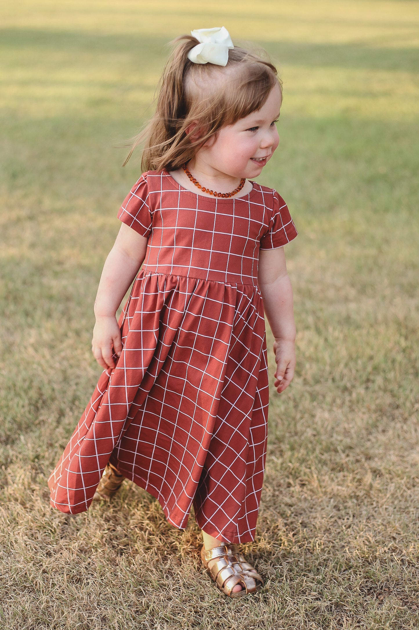Girl in modest checkered dress, ready for nursing.