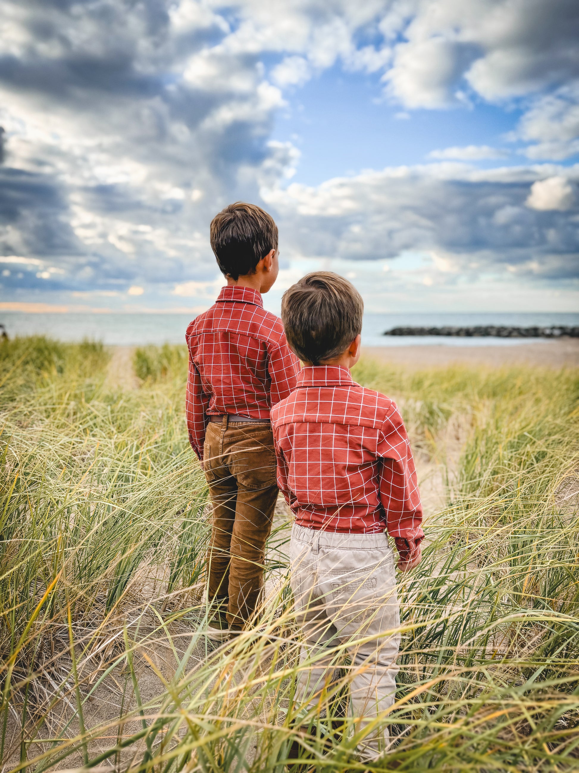 Two boys red plaid in tall grass