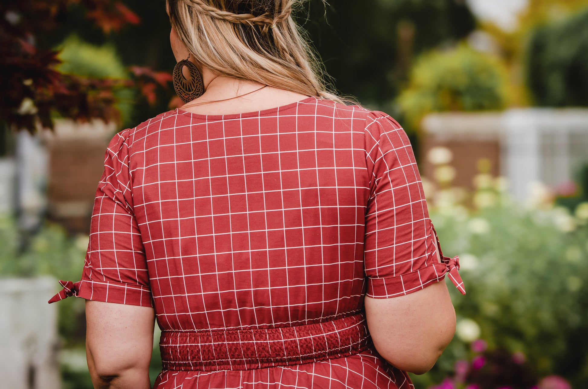Woman in modest nursing checkered dress garden