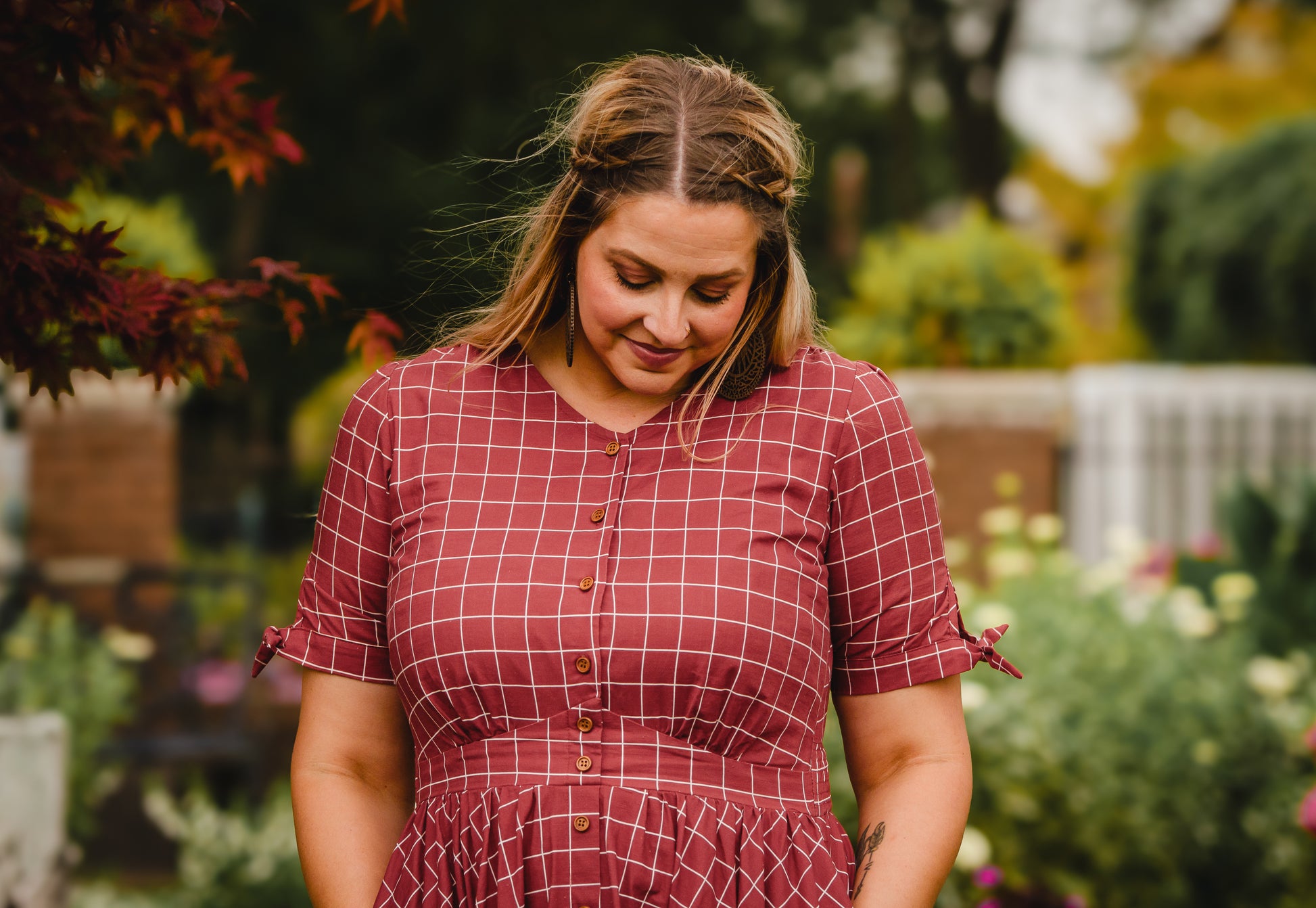 Woman in modest nursing checkered dress garden