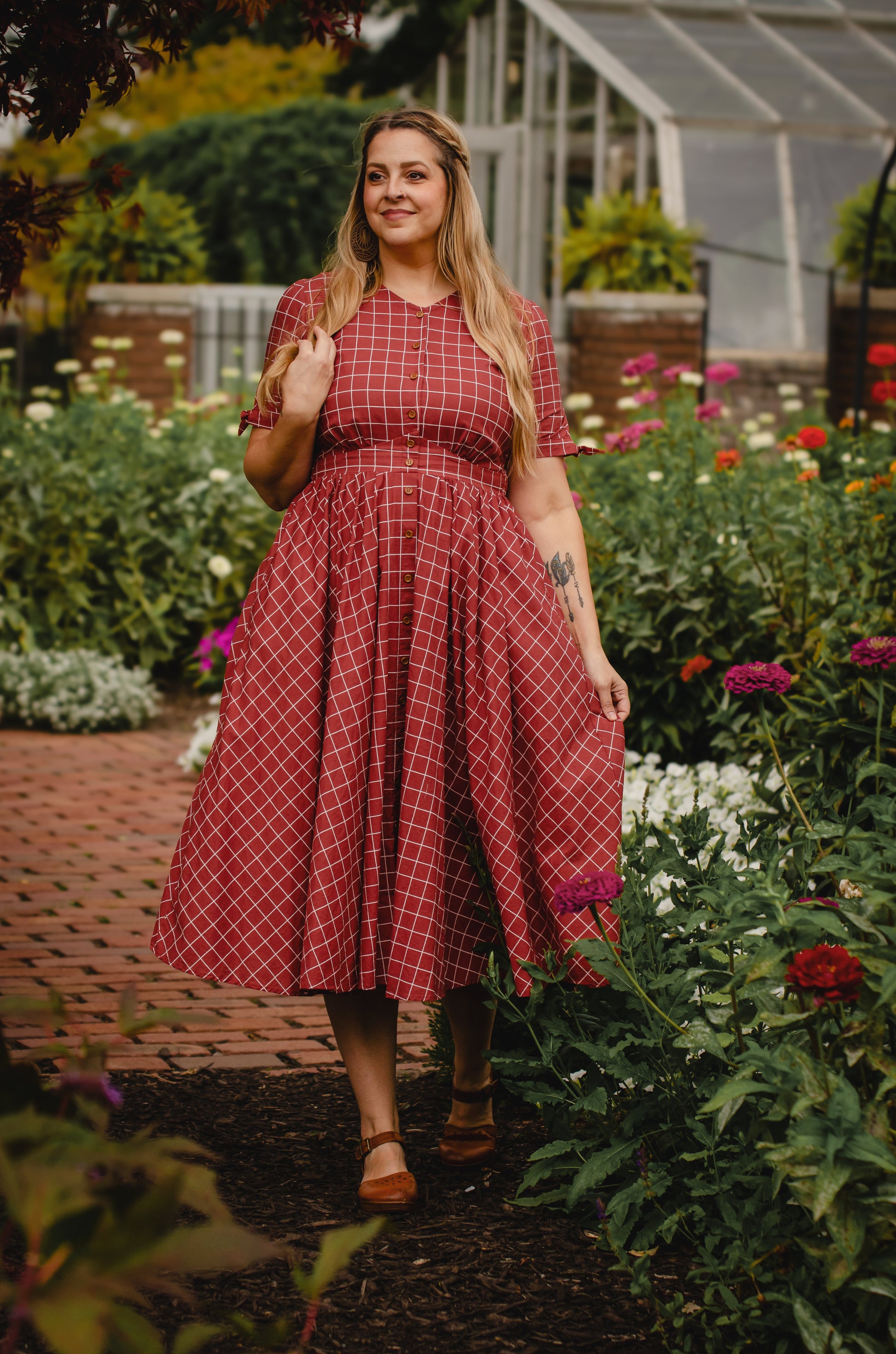 Woman in modest nursing checkered dress garden