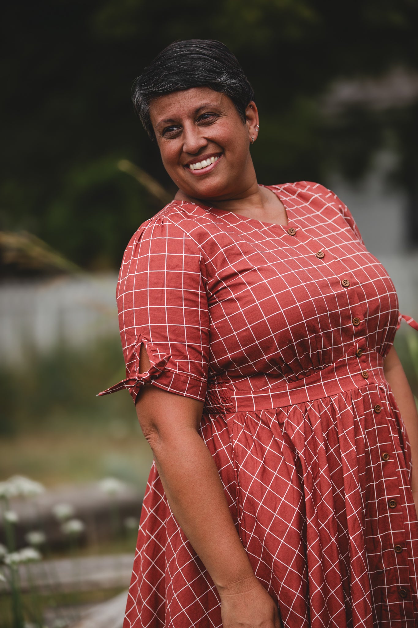 Woman in modest nursing checkered dress outdoors