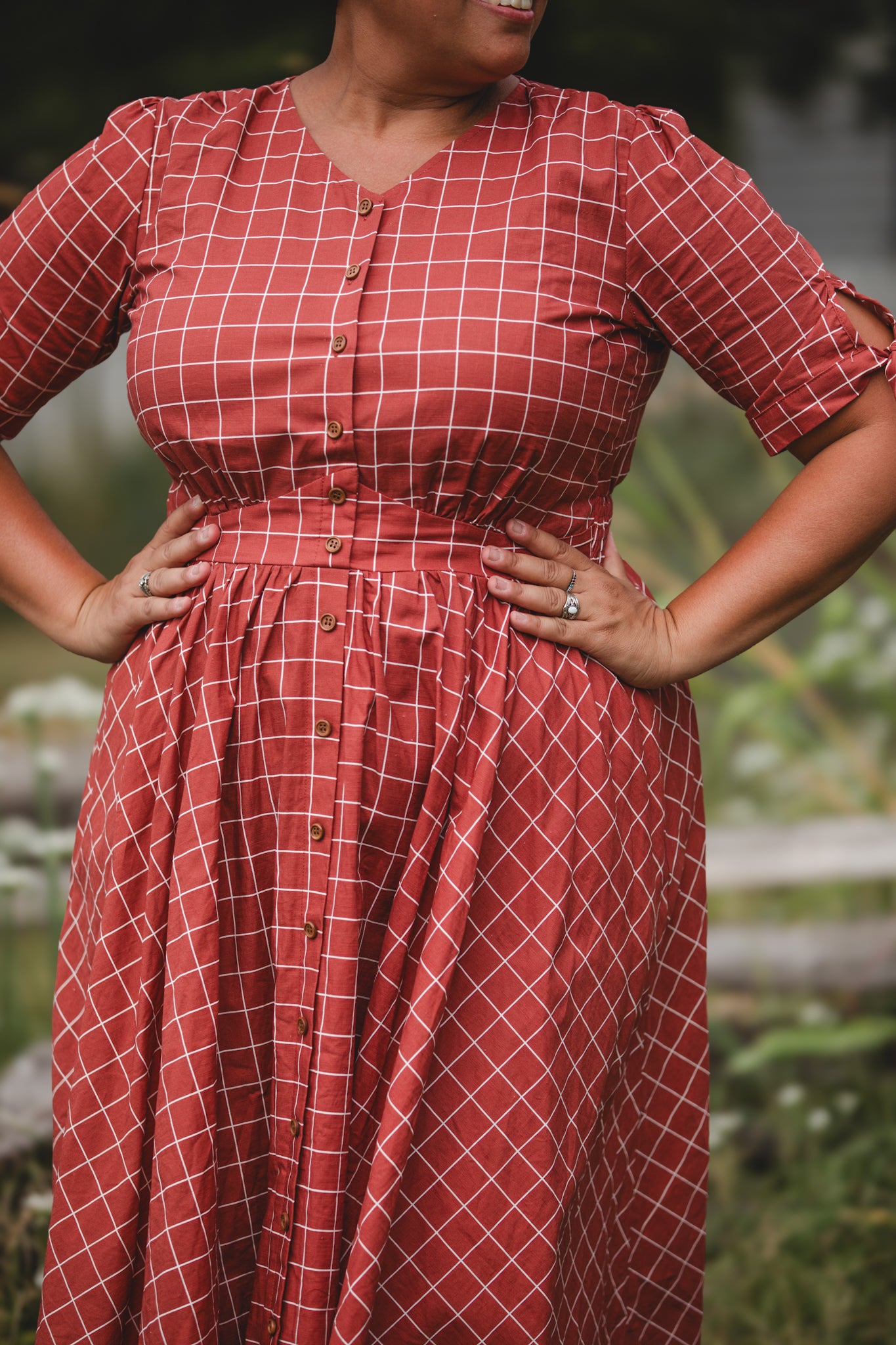 Woman in modest nursing red checkered dress outdoors