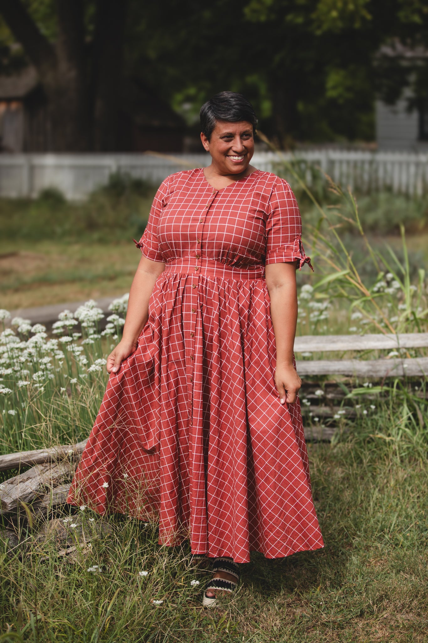 Woman in modest nursing red checkered dress garden