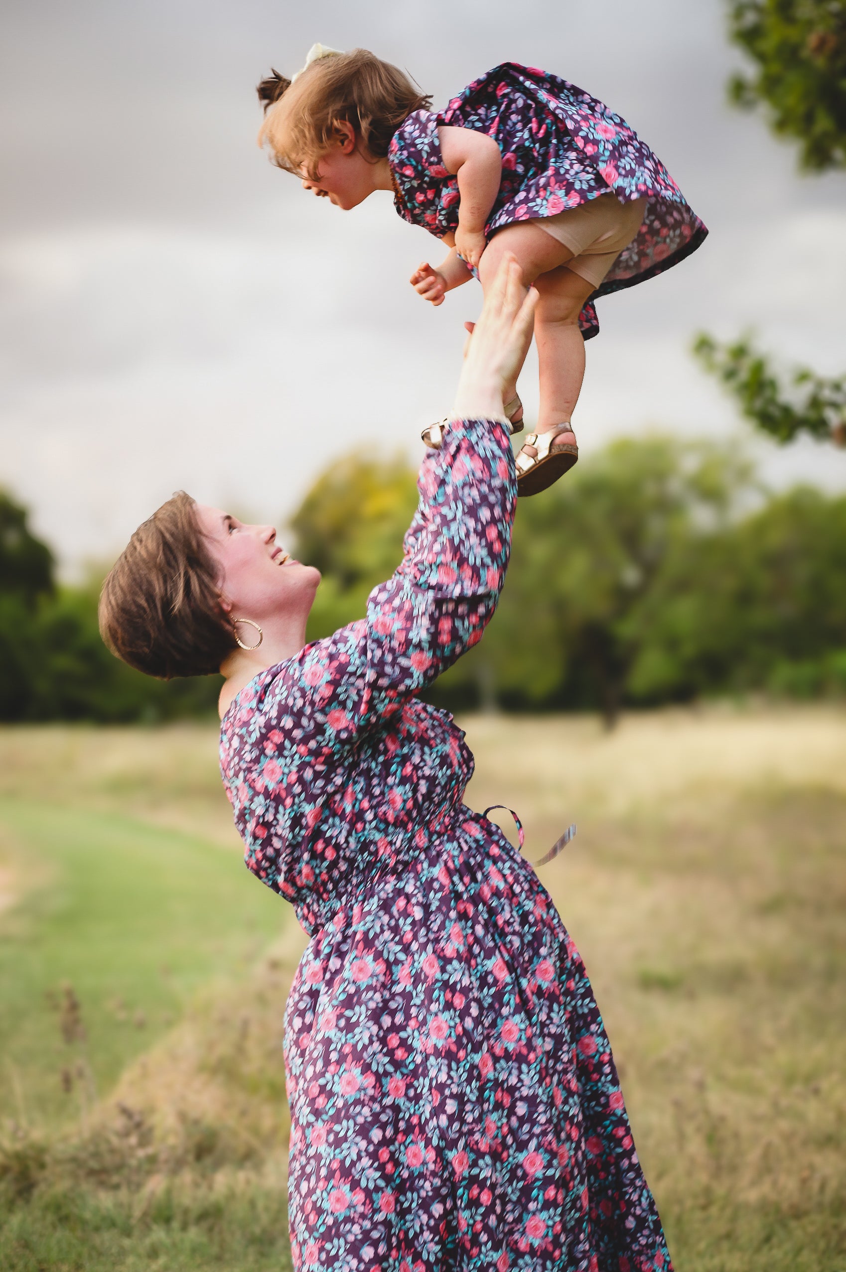 Woman in modest nursing dress lifting child