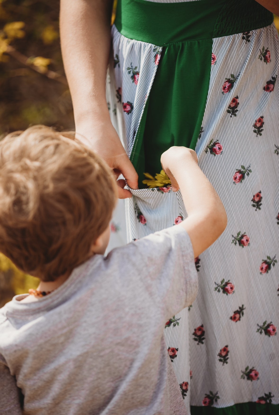 woman wearing a green and white striped modest nursing dress with her son