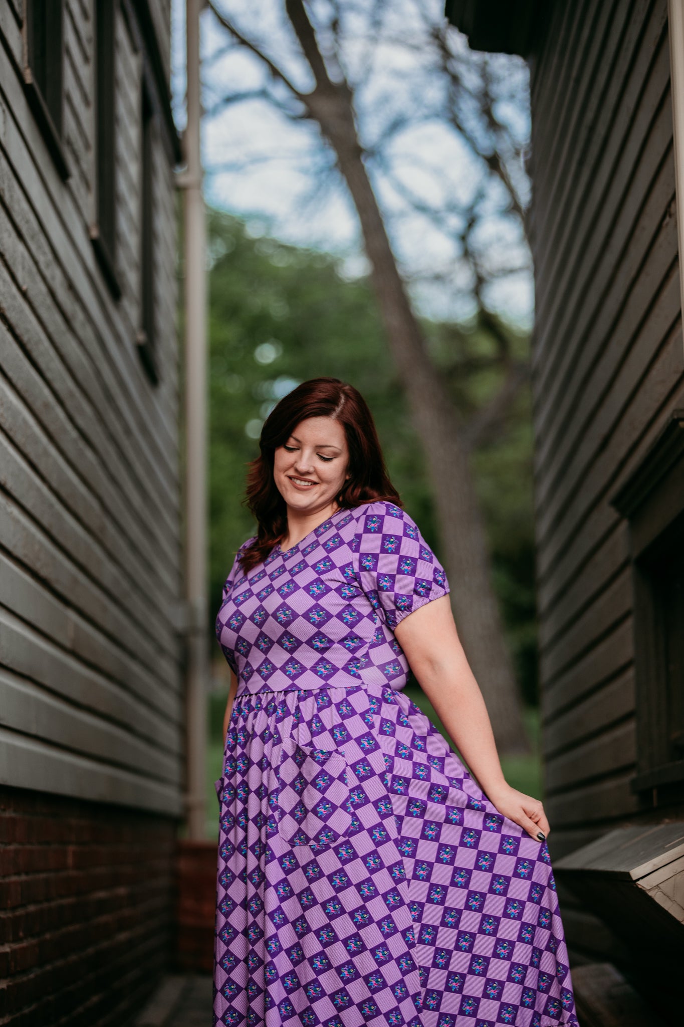 Woman in a purple checkered modest nursing dress.