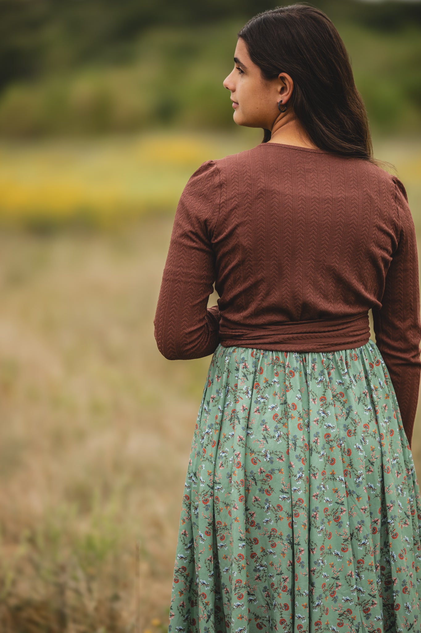 Woman in modest nursing dress standing in field