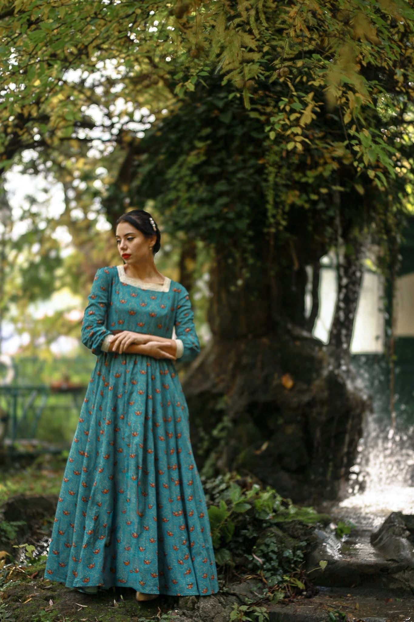 Woman in modest nursing teal dress in park