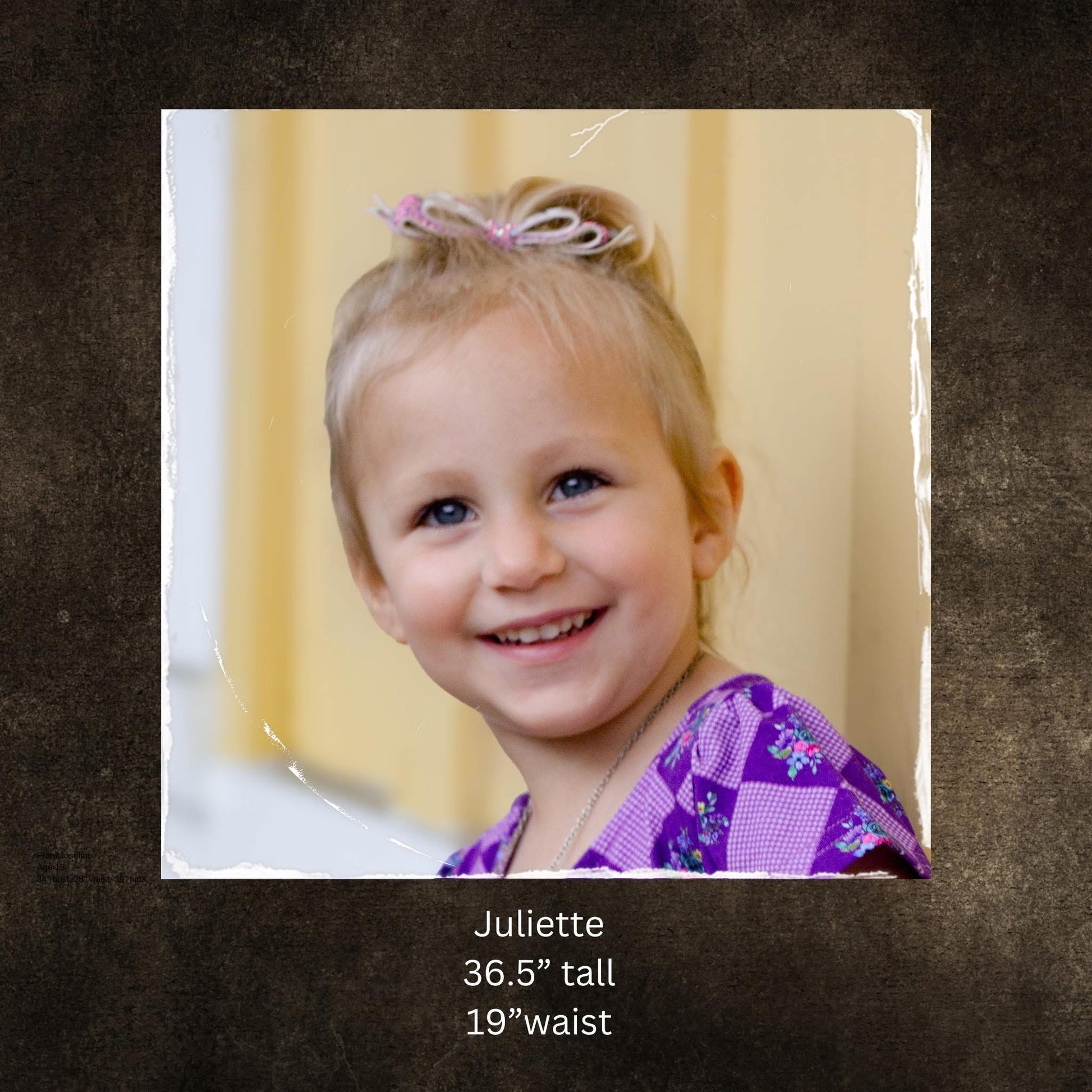 Young girl with a purple hair bow, smiling at the camera against a neutral background.