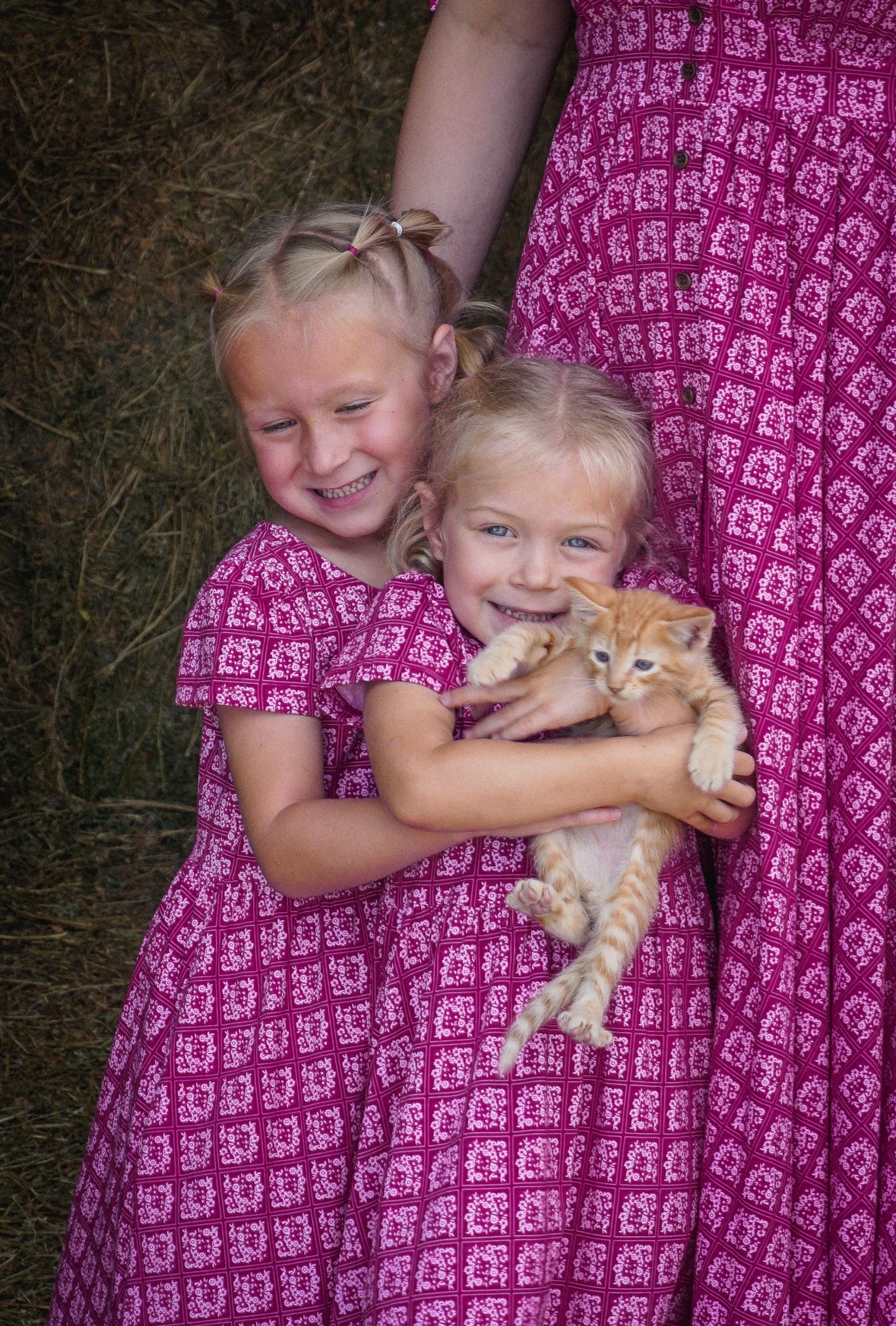 Young girls in modest pink dresses with their mother wearing a modest pink nursing dress