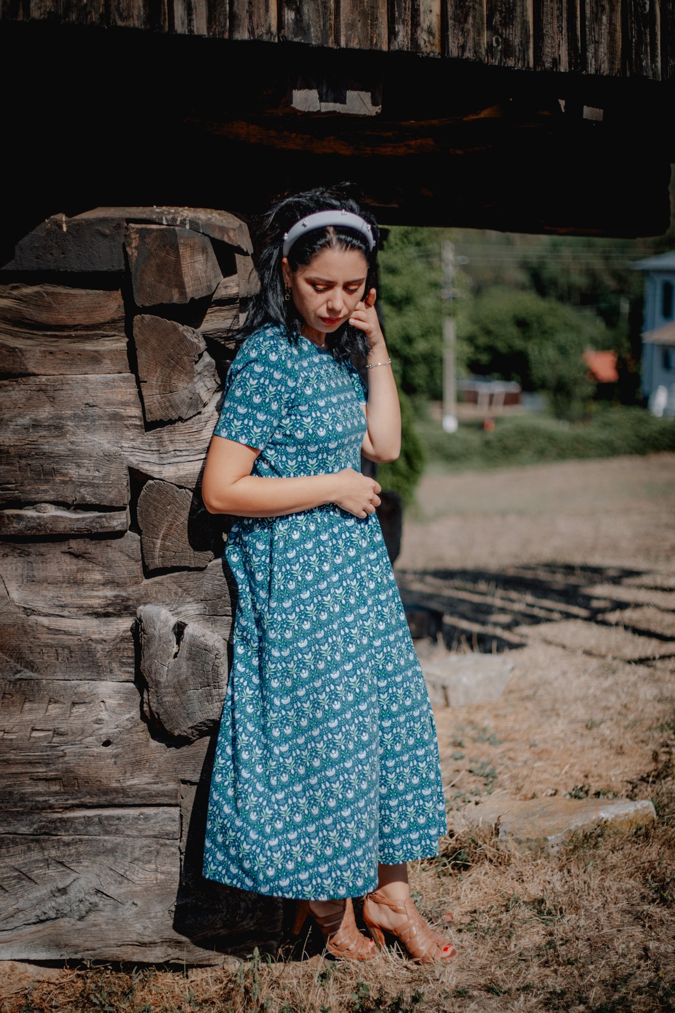 Woman in modest nursing dress, blue floral field.