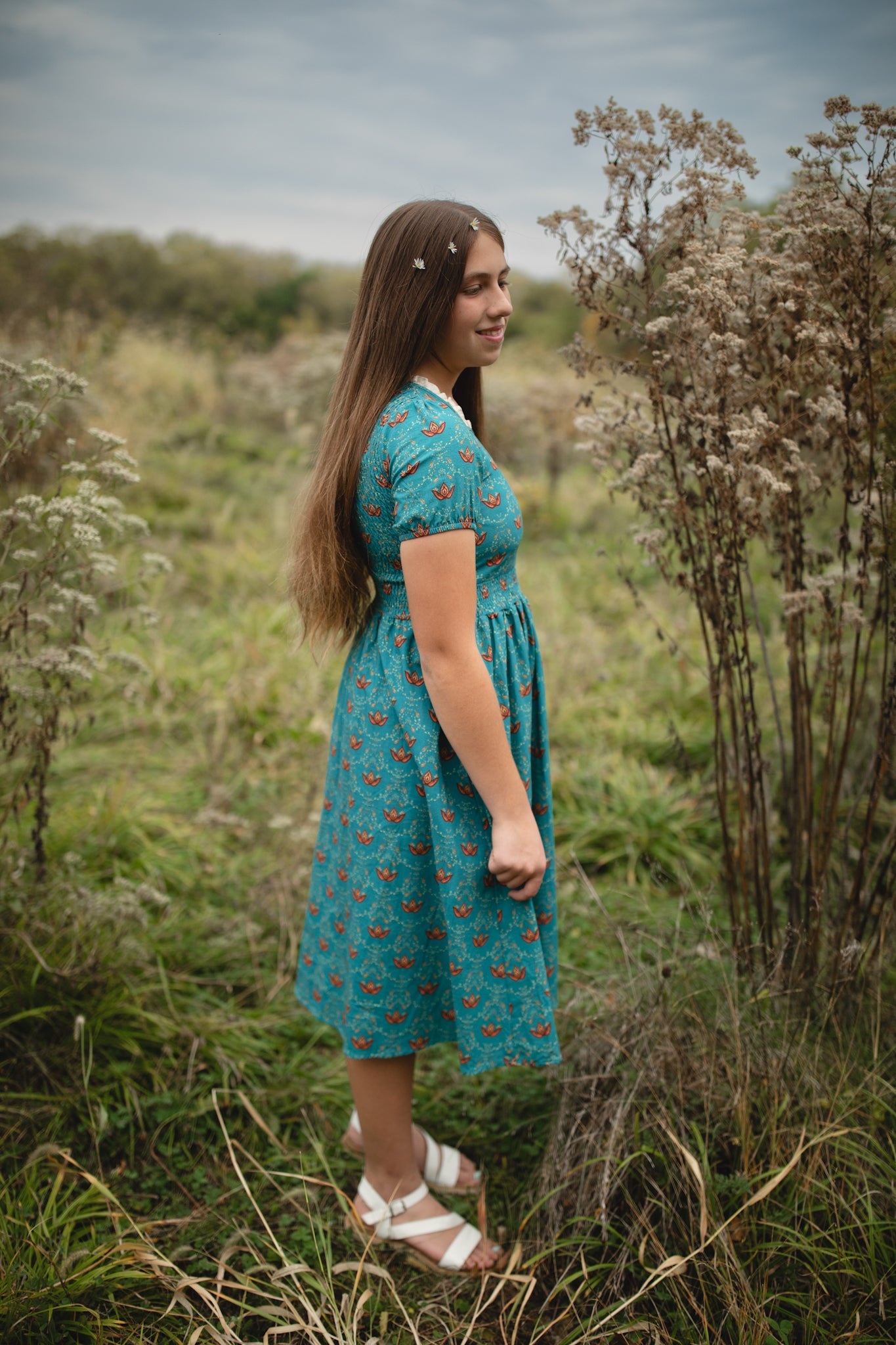Woman wearing modest nursing dress in wildflower field.