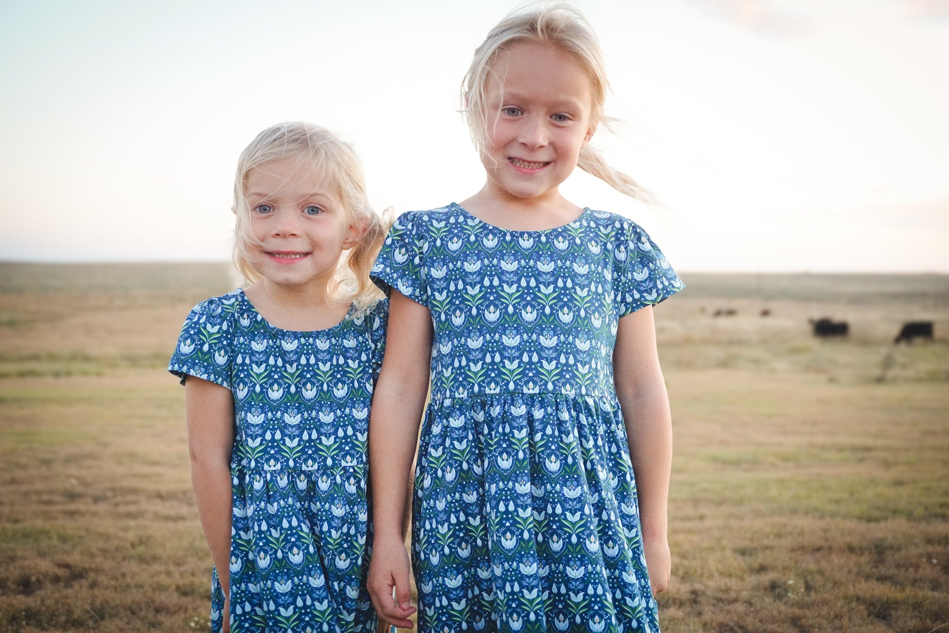 Two girls in modest floral dresses at sunset
