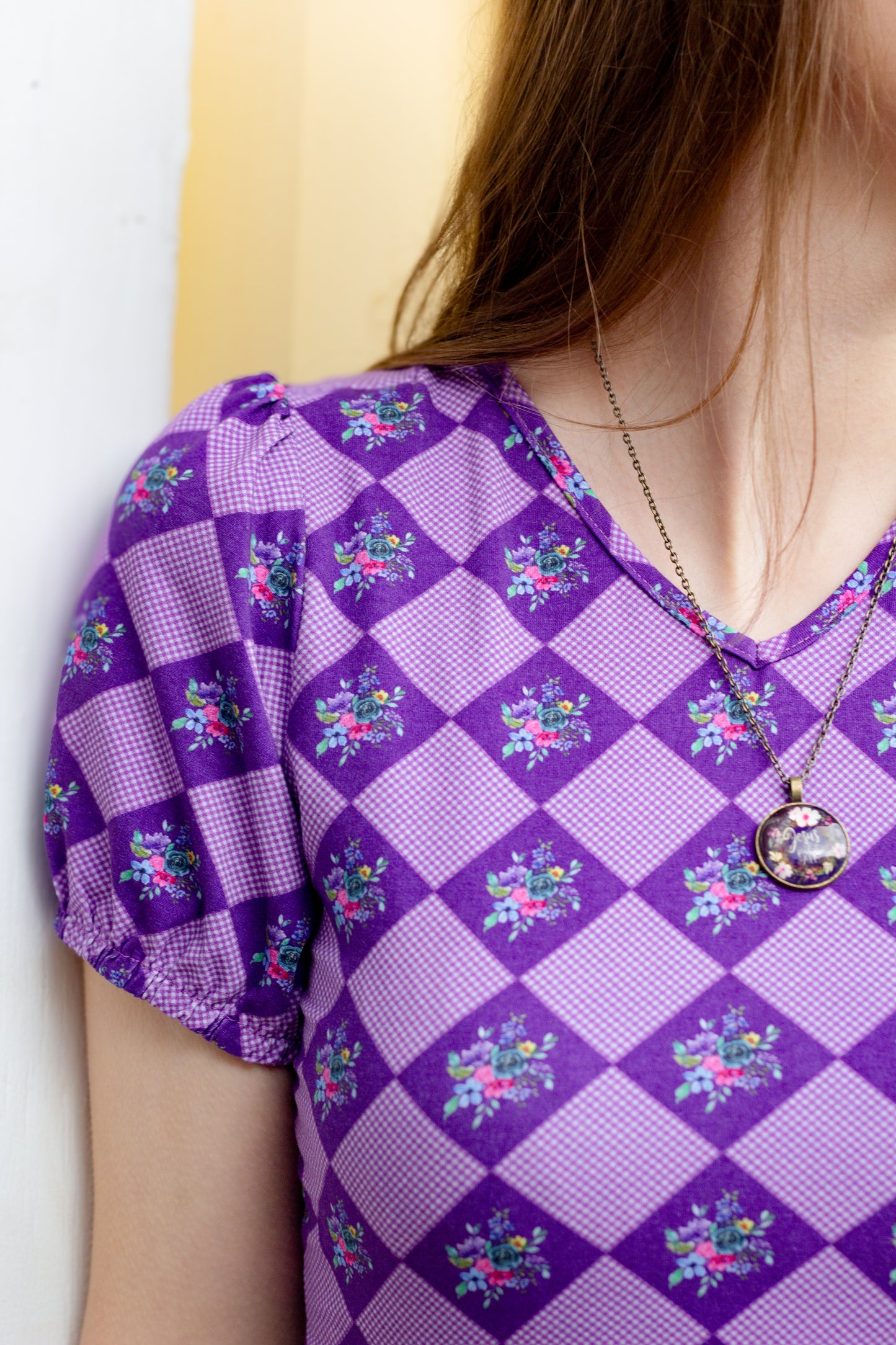 Woman in a purple checkered modest nursing dress.