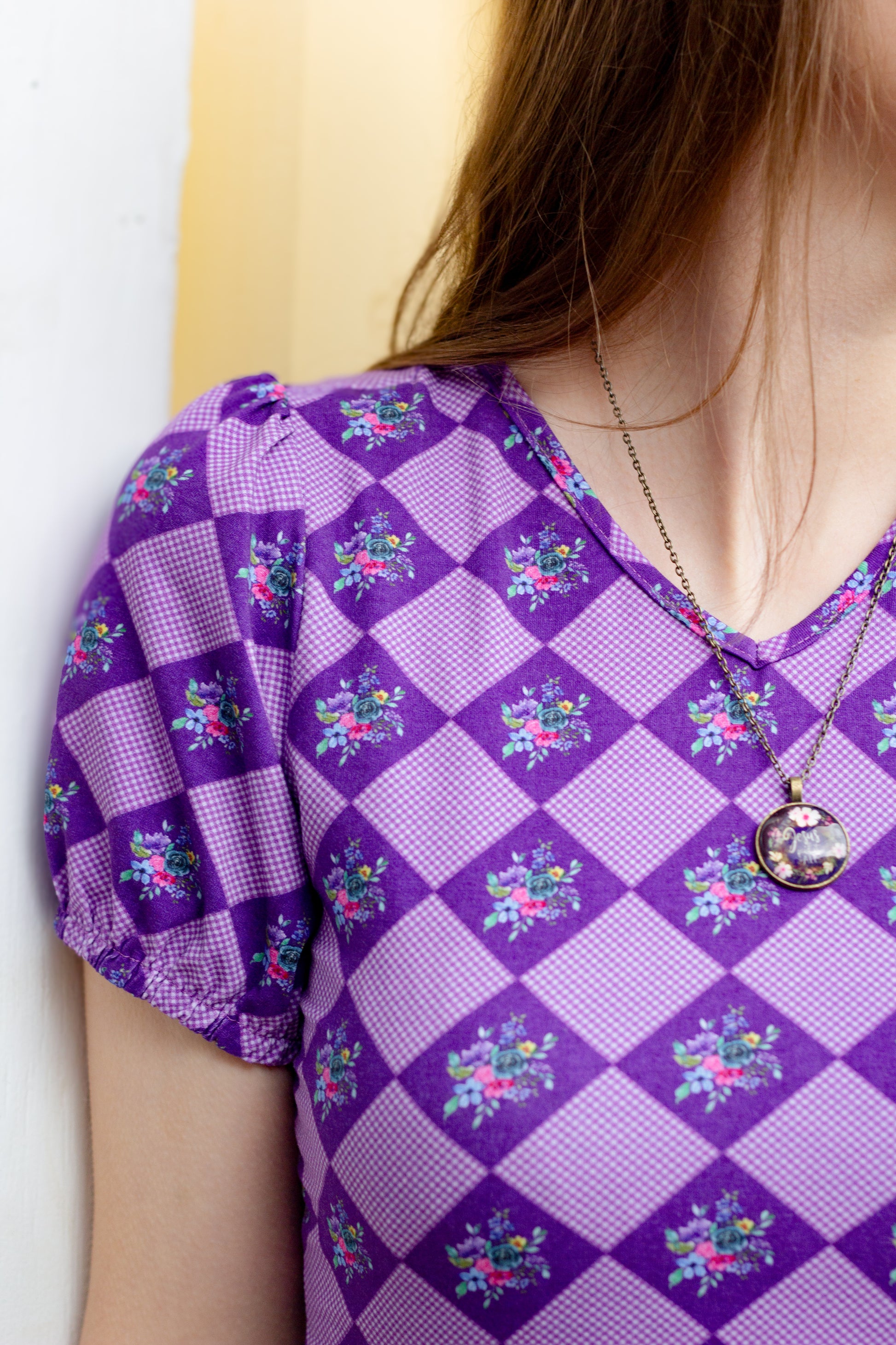 Woman in a purple checkered modest nursing dress.