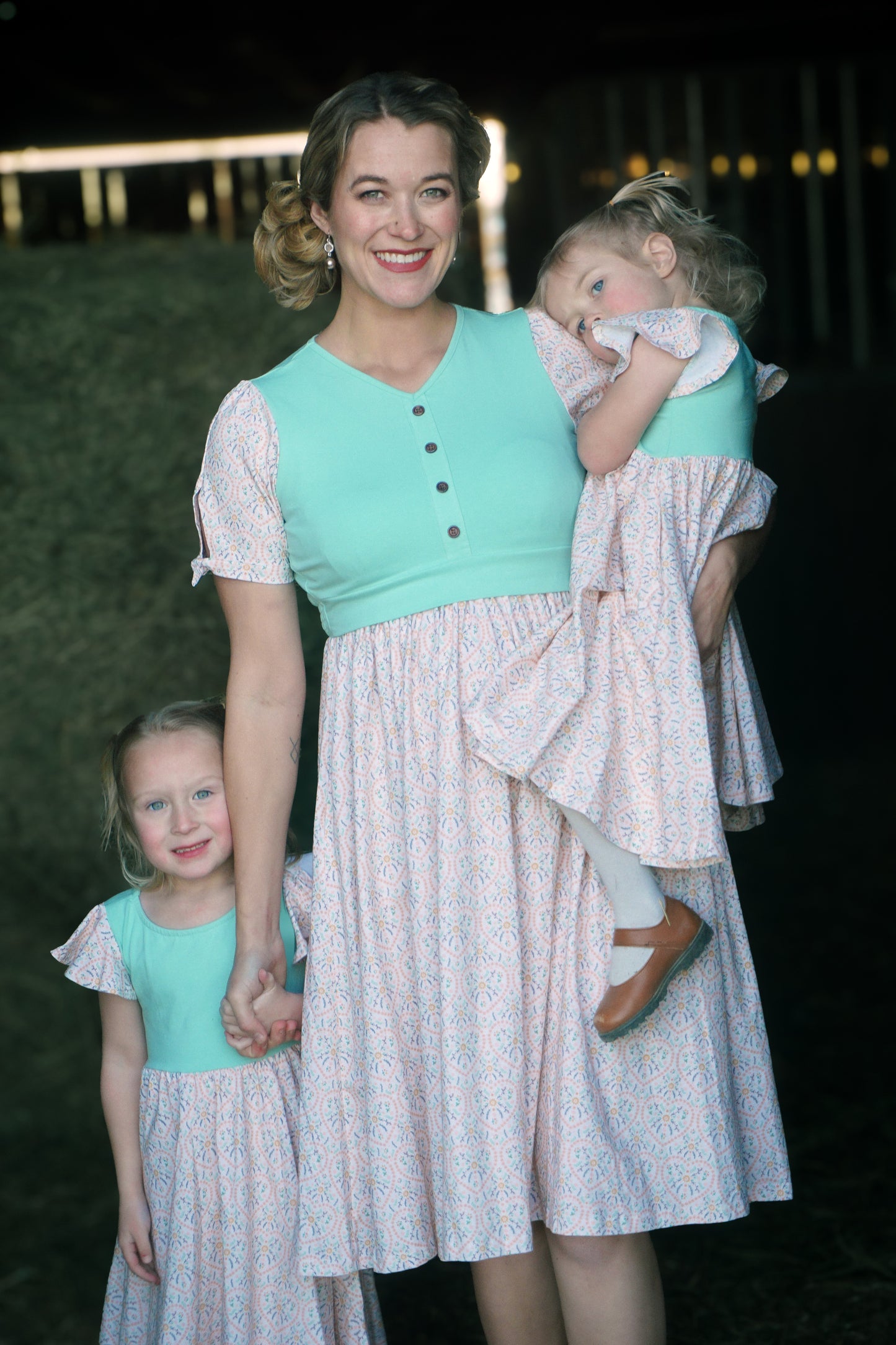 A mother and her daughters wearing vintage style modest dresses.