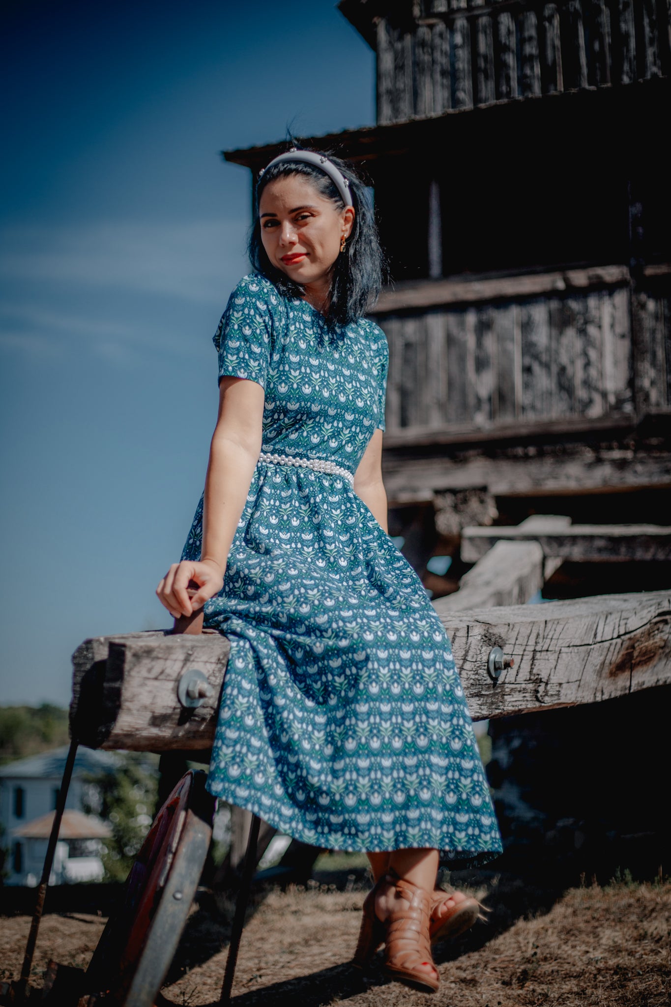 Woman in modest nursing dress, sitting on cart.