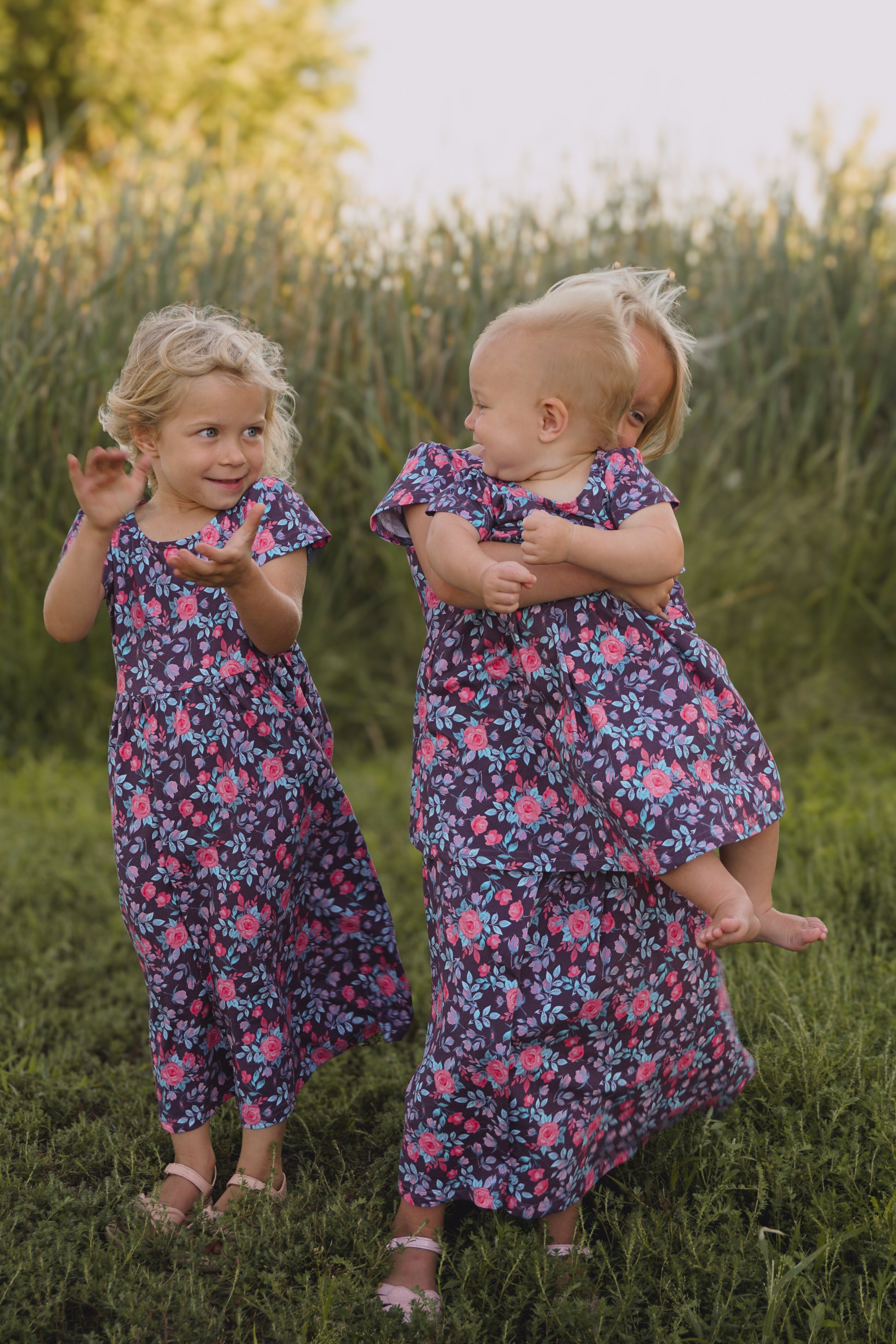 Two girls in matching floral dresses outdoors