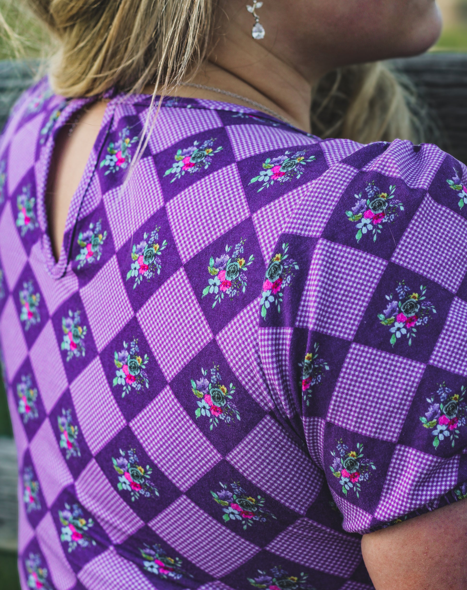 Woman in a purple checkered modest nursing dress.