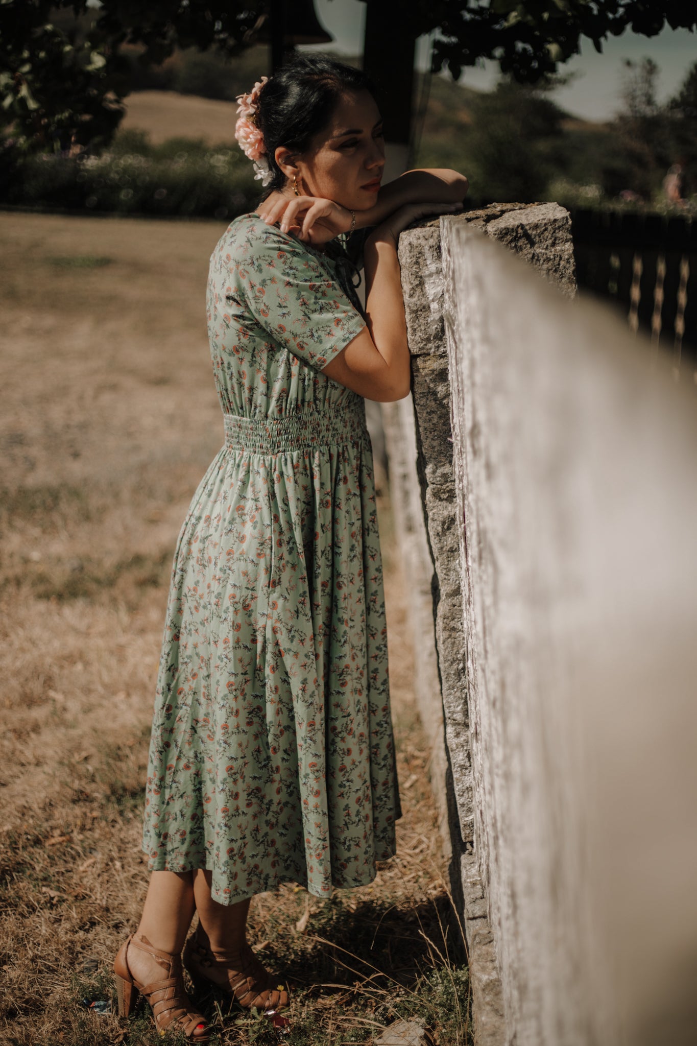 Woman in modest nursing dress by fence